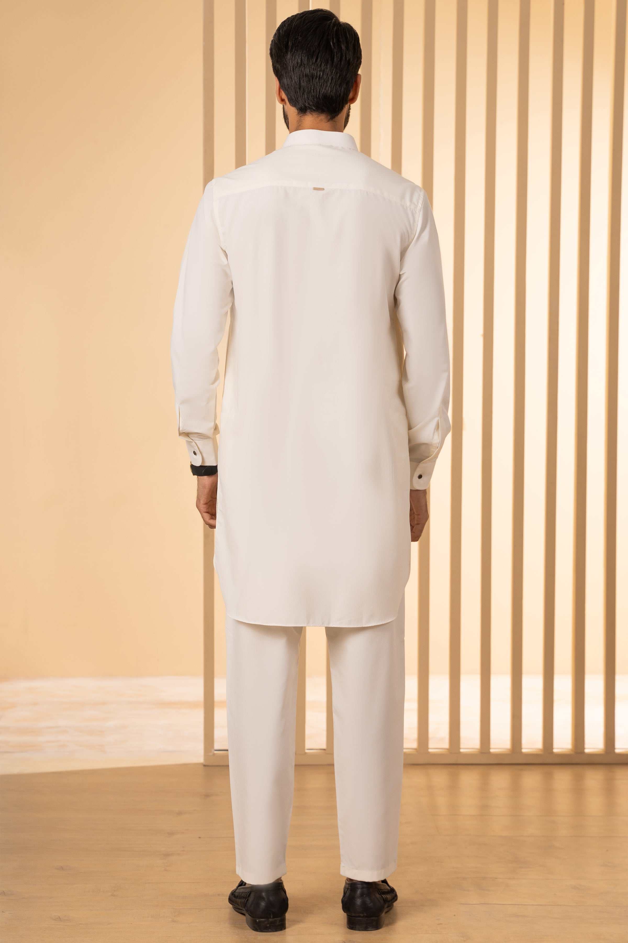 Off-white kurta pajama set on model, back view; long tunic and straight-leg pants.