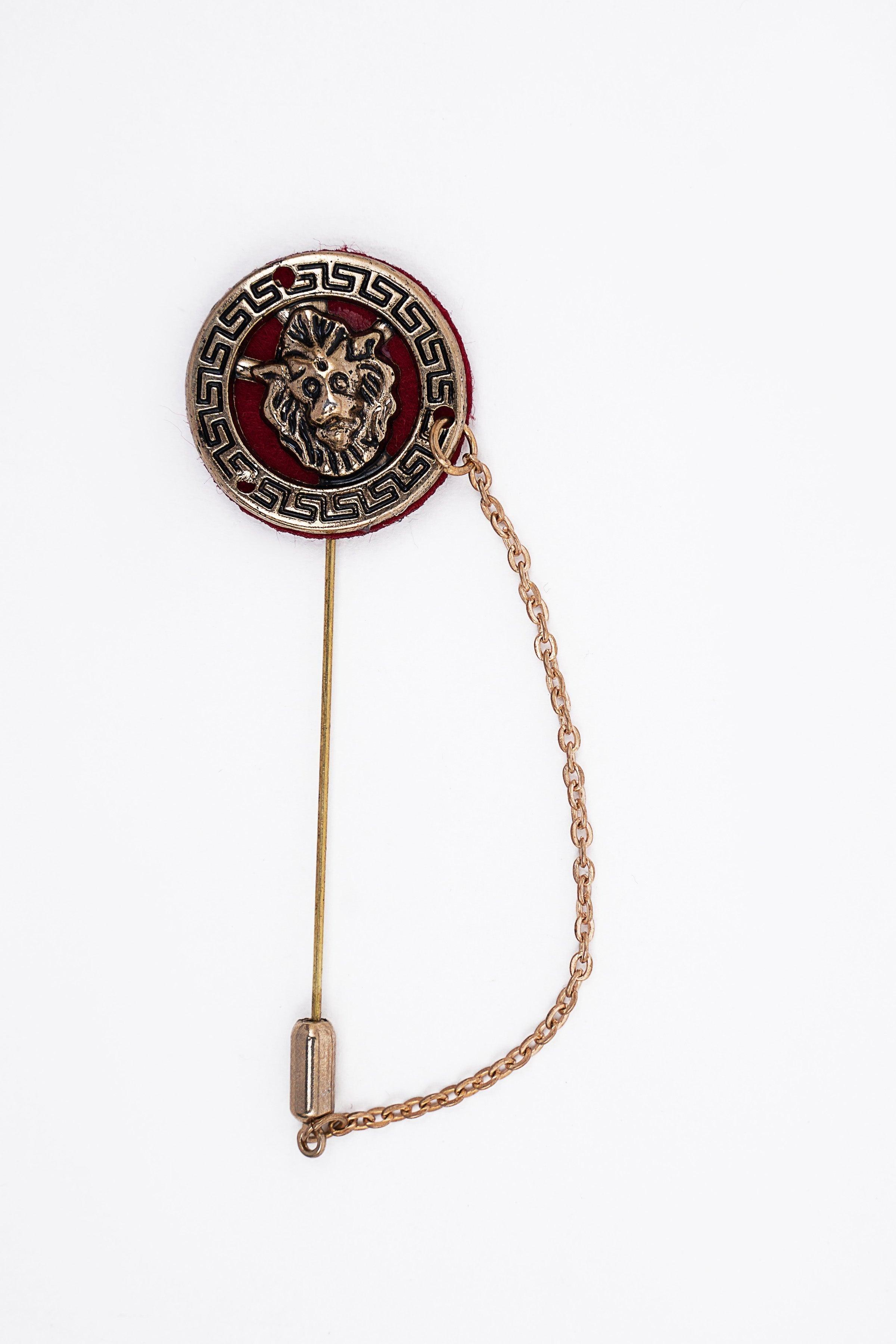 Round enamel lapel pin with lion face medallion, red center, gold-tone chain and clasp pin