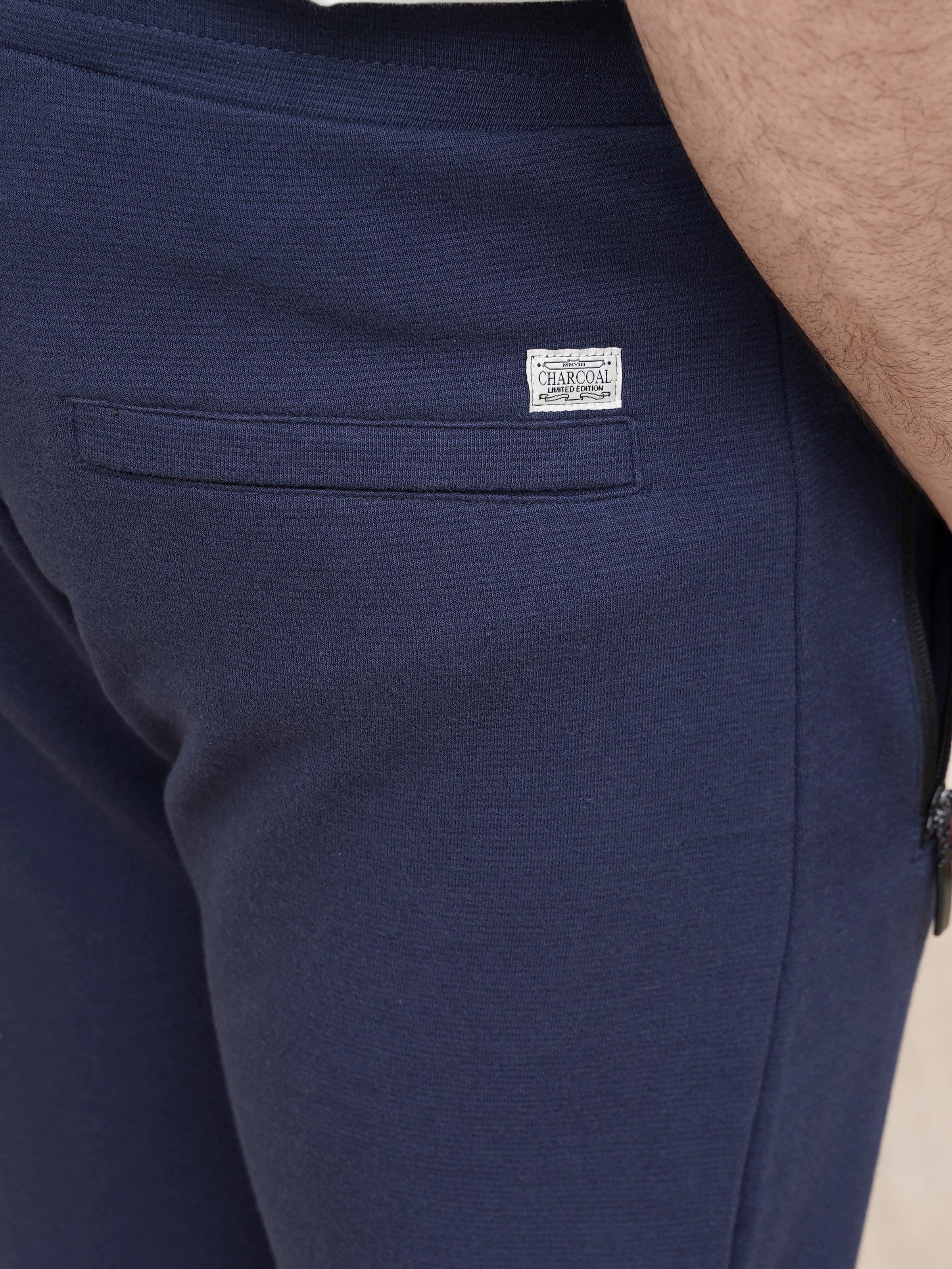 Dark blue jogger trousers with woven brand patch on waistband