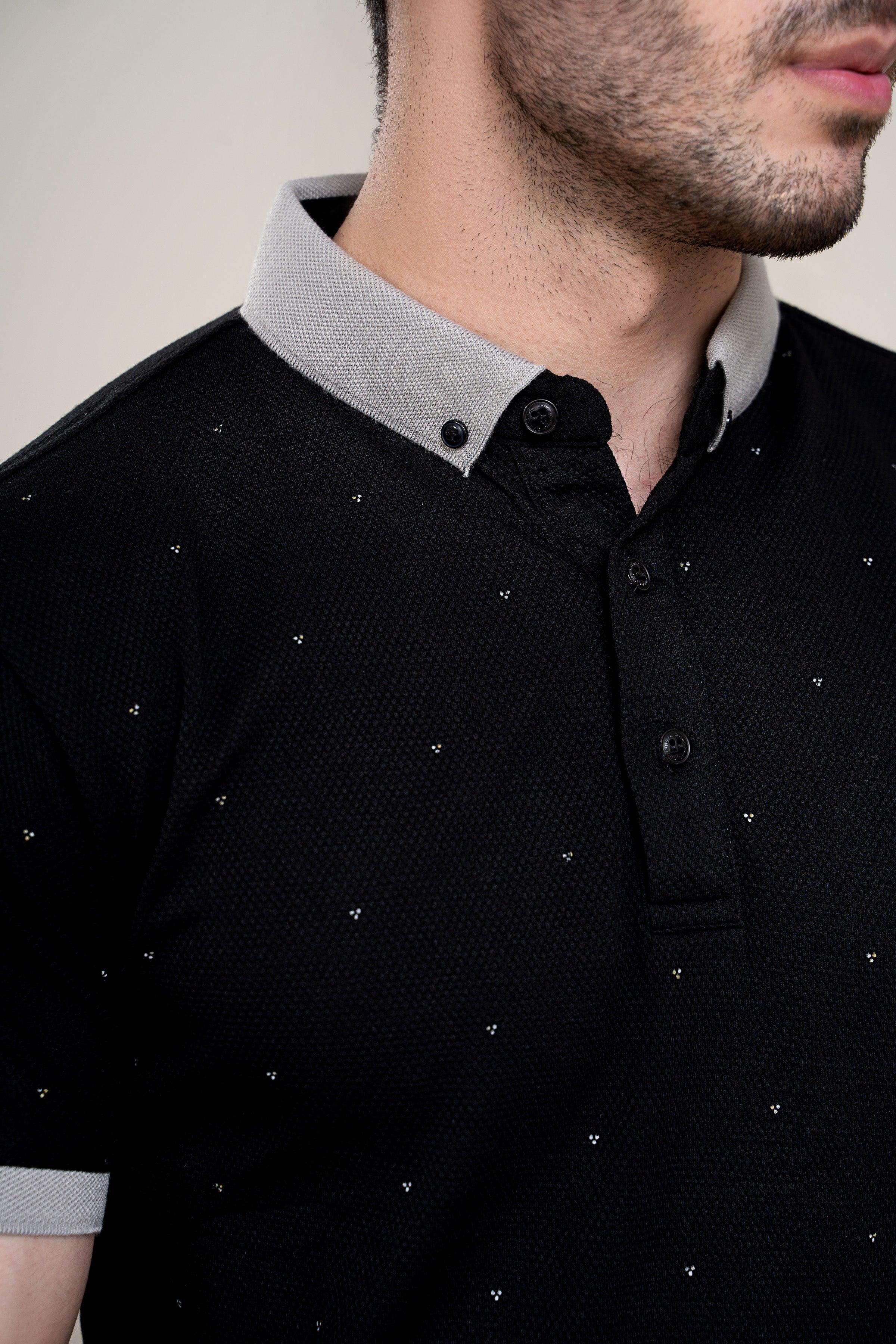 Close-up of black polo collar with white trim and button placket details