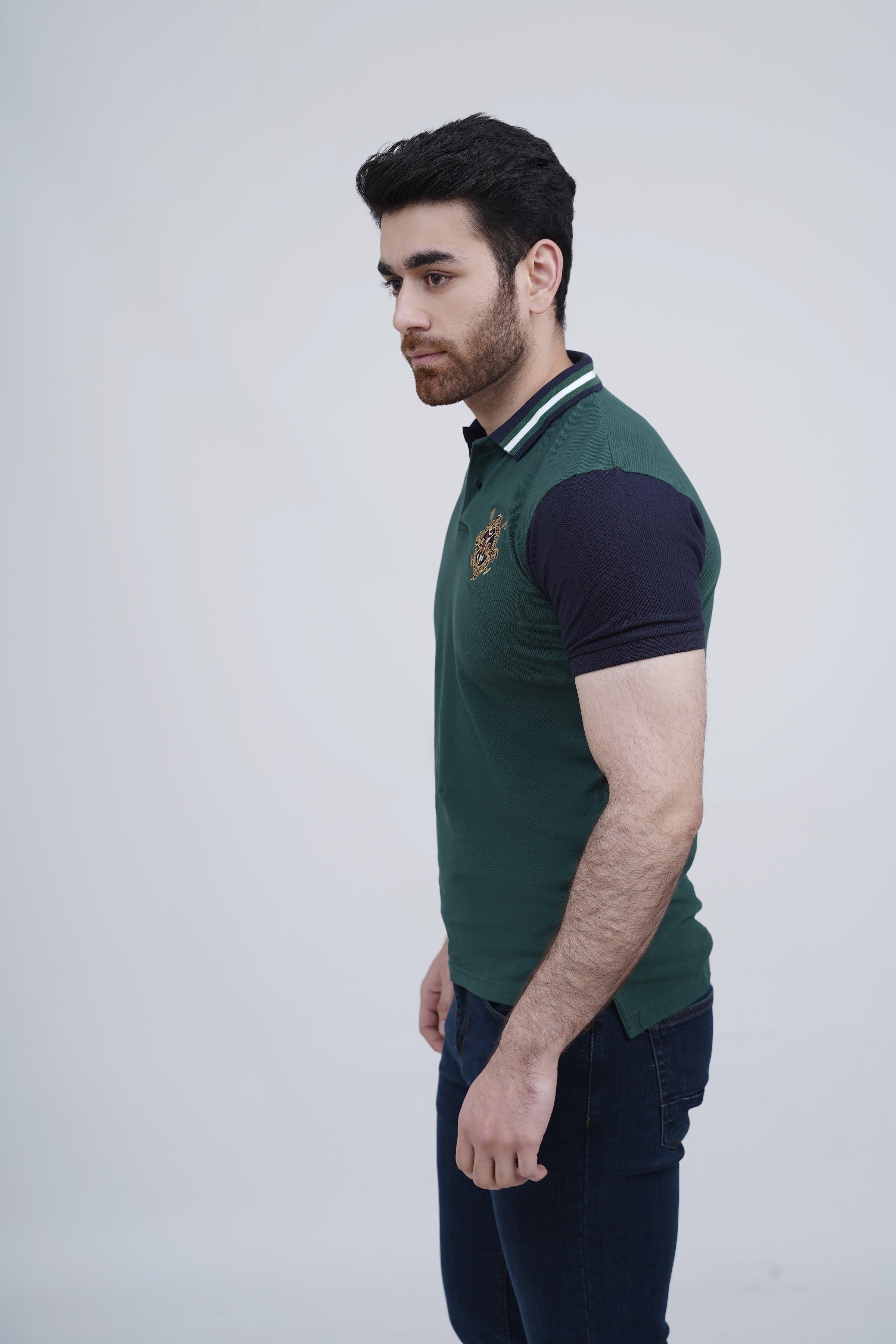 Green polo shirt with navy sleeves and striped collar trim, crest on chest