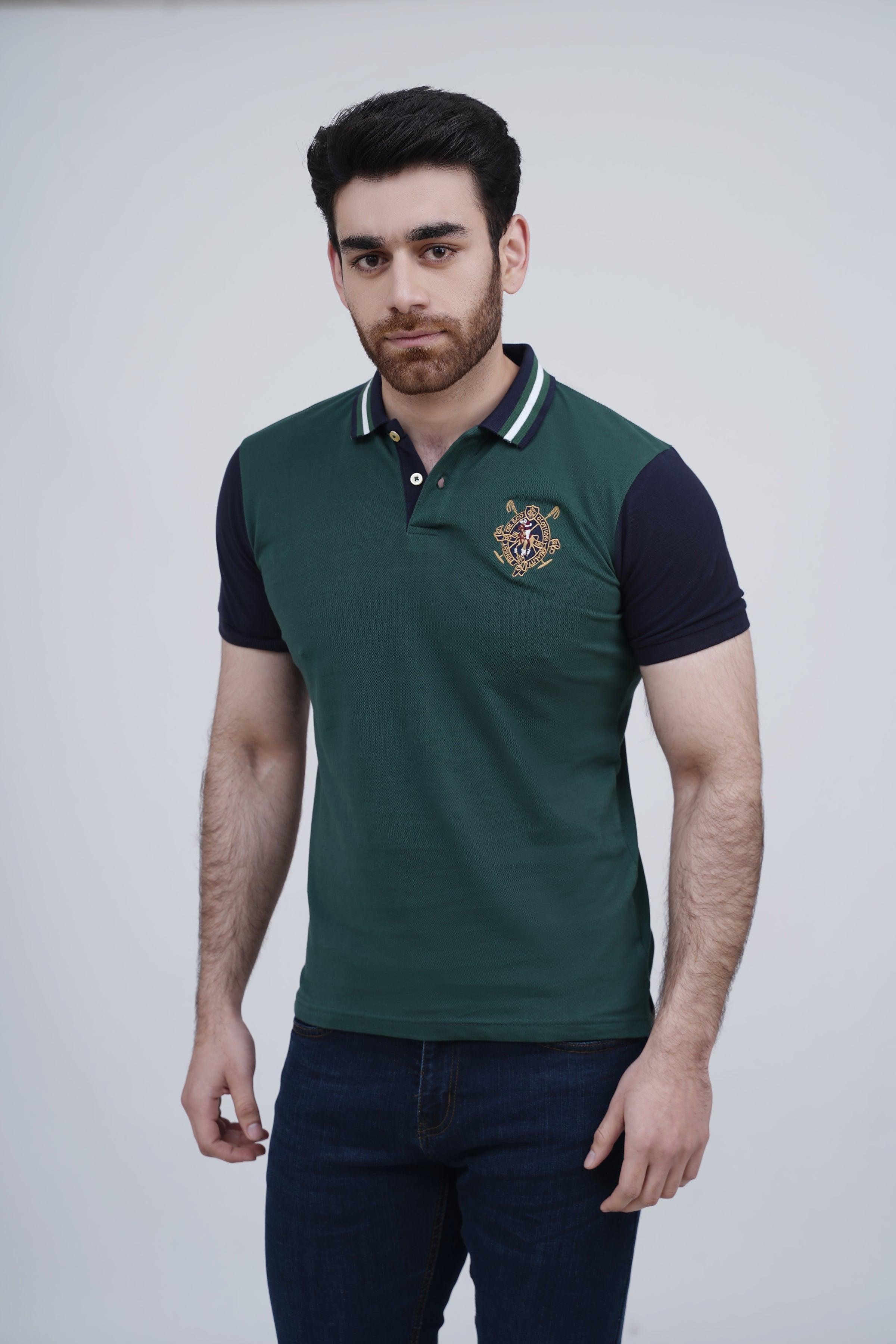 Green polo shirt with navy sleeves, striped collar trim, crest logo at chest