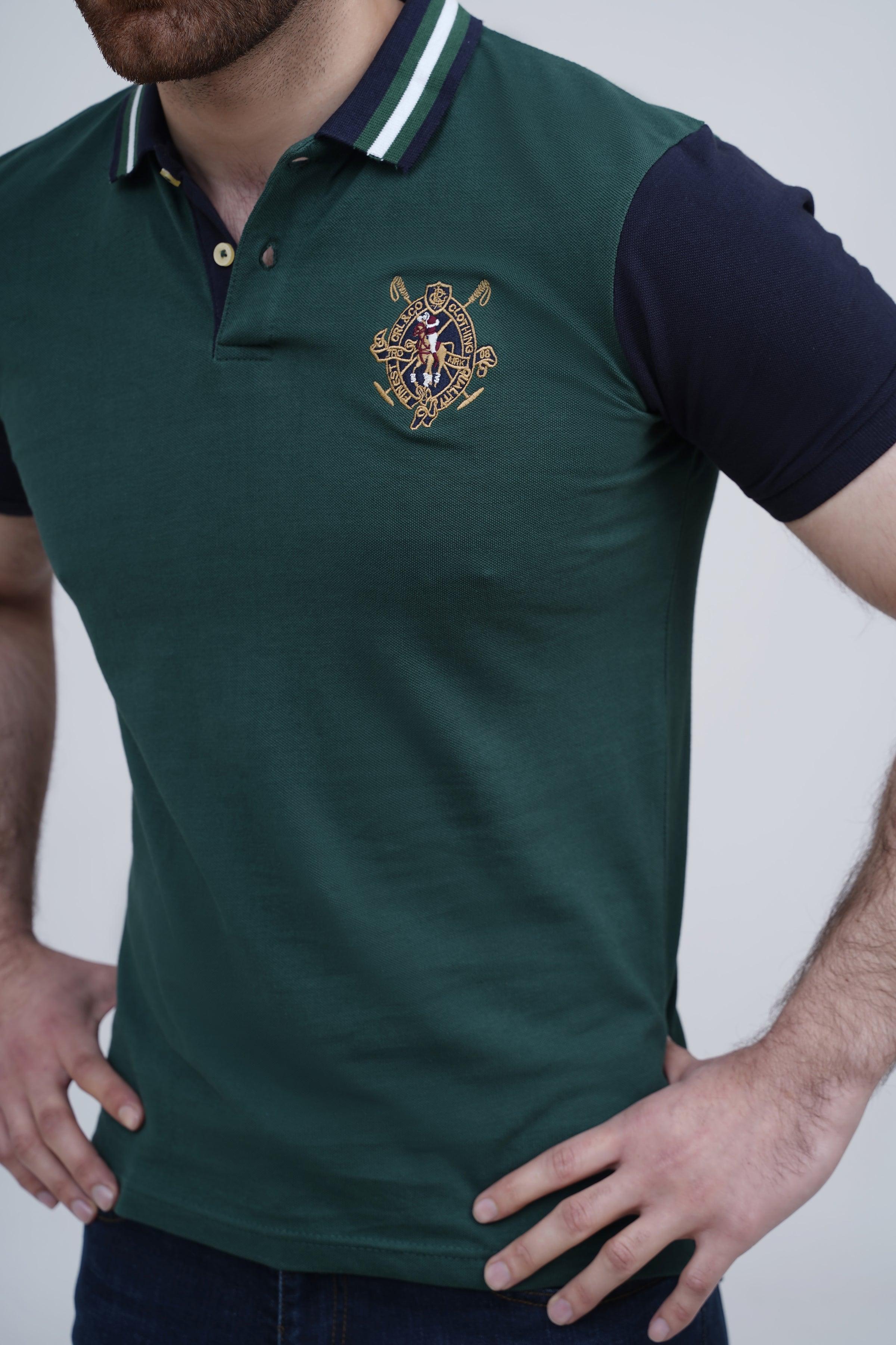 Green polo shirt with striped collar and crest logo detail, navy sleeve visible