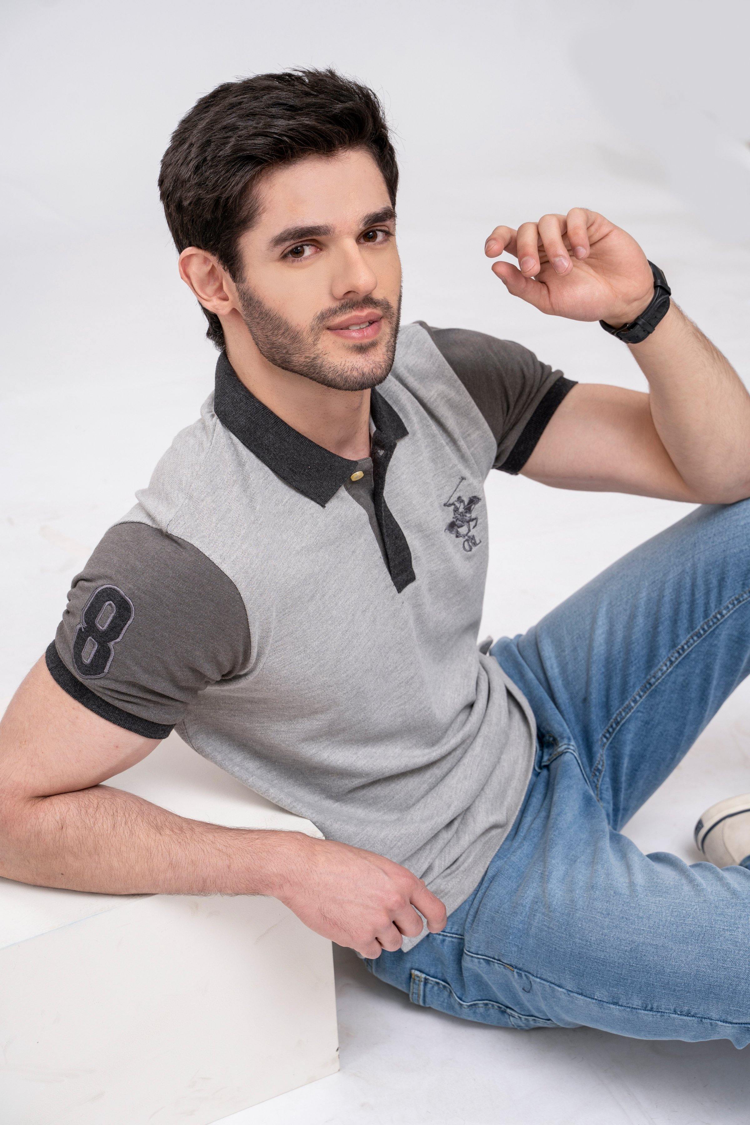 Grey polo shirt with dark collar, buttons, and embroidered chest logo