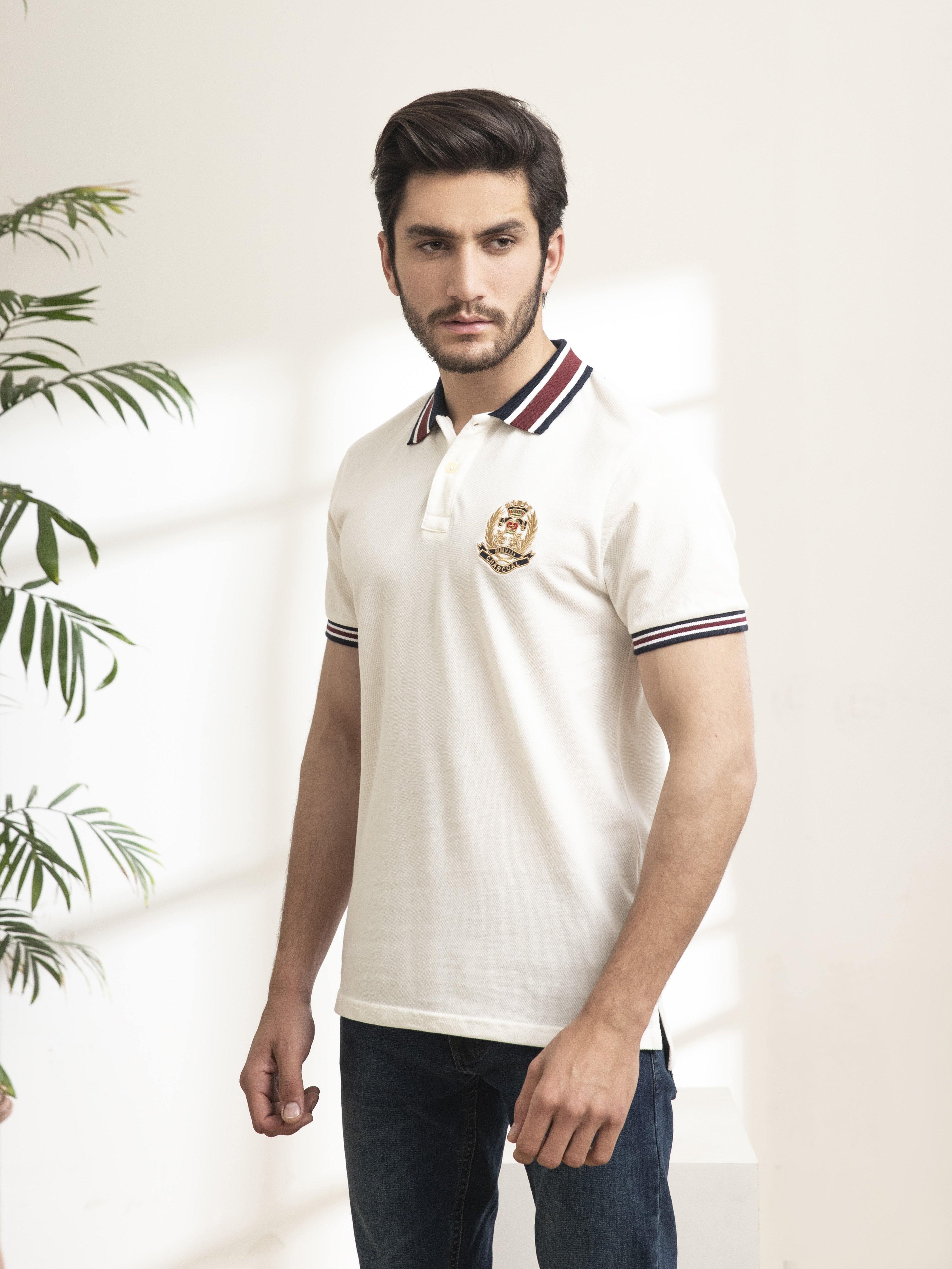 Off-white polo shirt with striped collar, button placket, and crest badge on chest