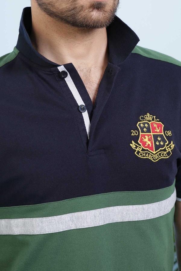Close-up navy green polo shirt with embroidered crest, button placket, and striped trim