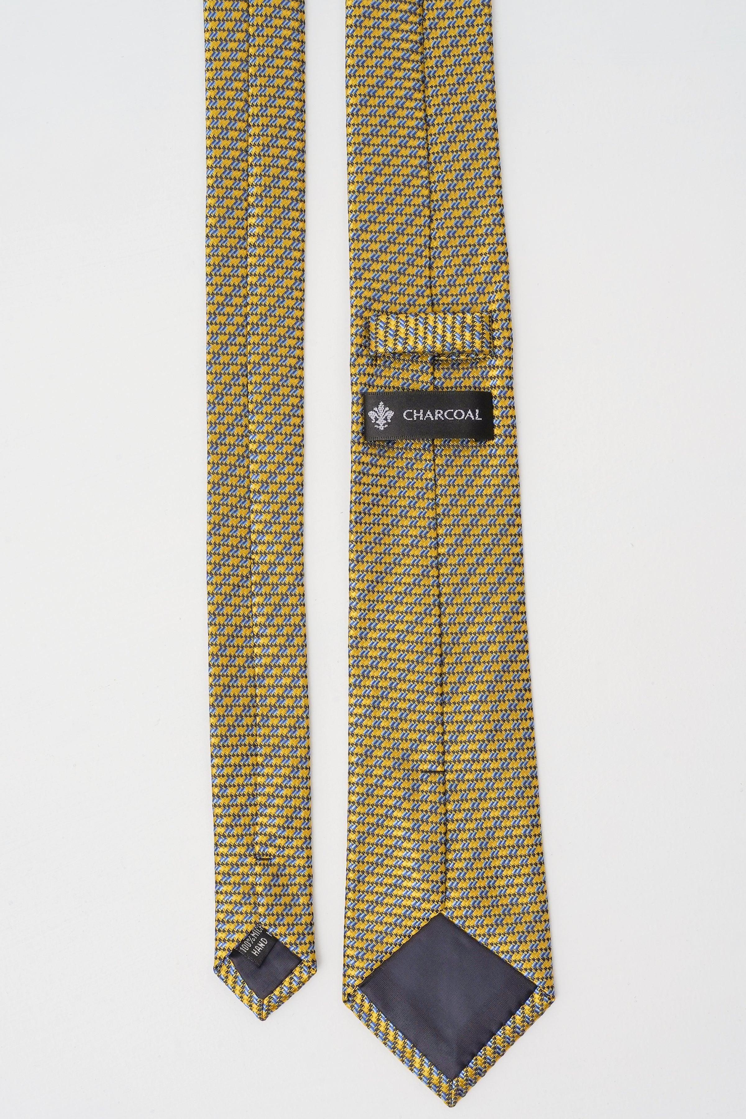 Patterned necktie label and folded blade tips, yellow with dark blue micro pattern.