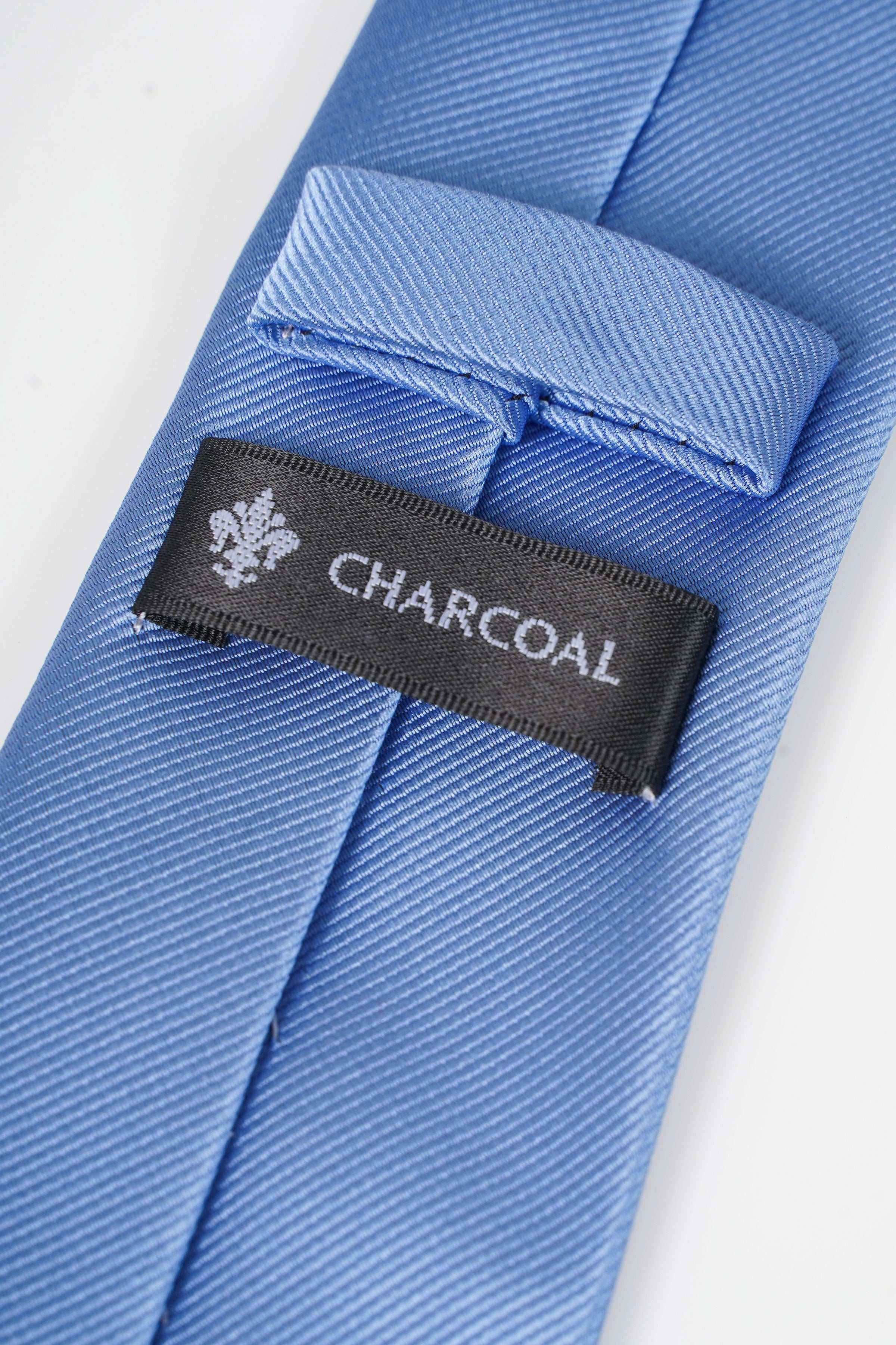 Light blue poly silk tie with Charcoal brand label at seam