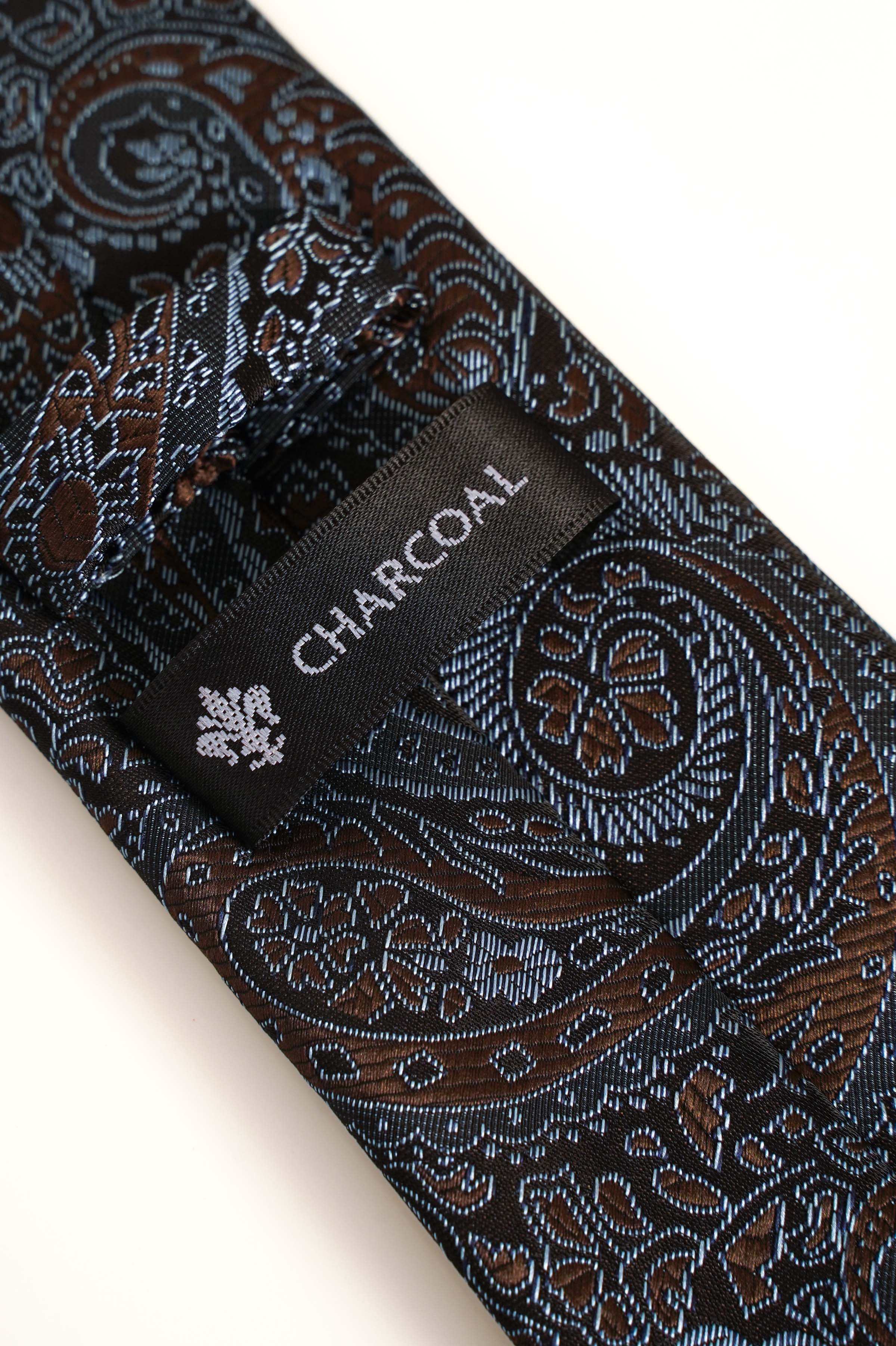 Paisley polyester tie with 'CHARCOAL' label, dark blue with rust and teal pattern.