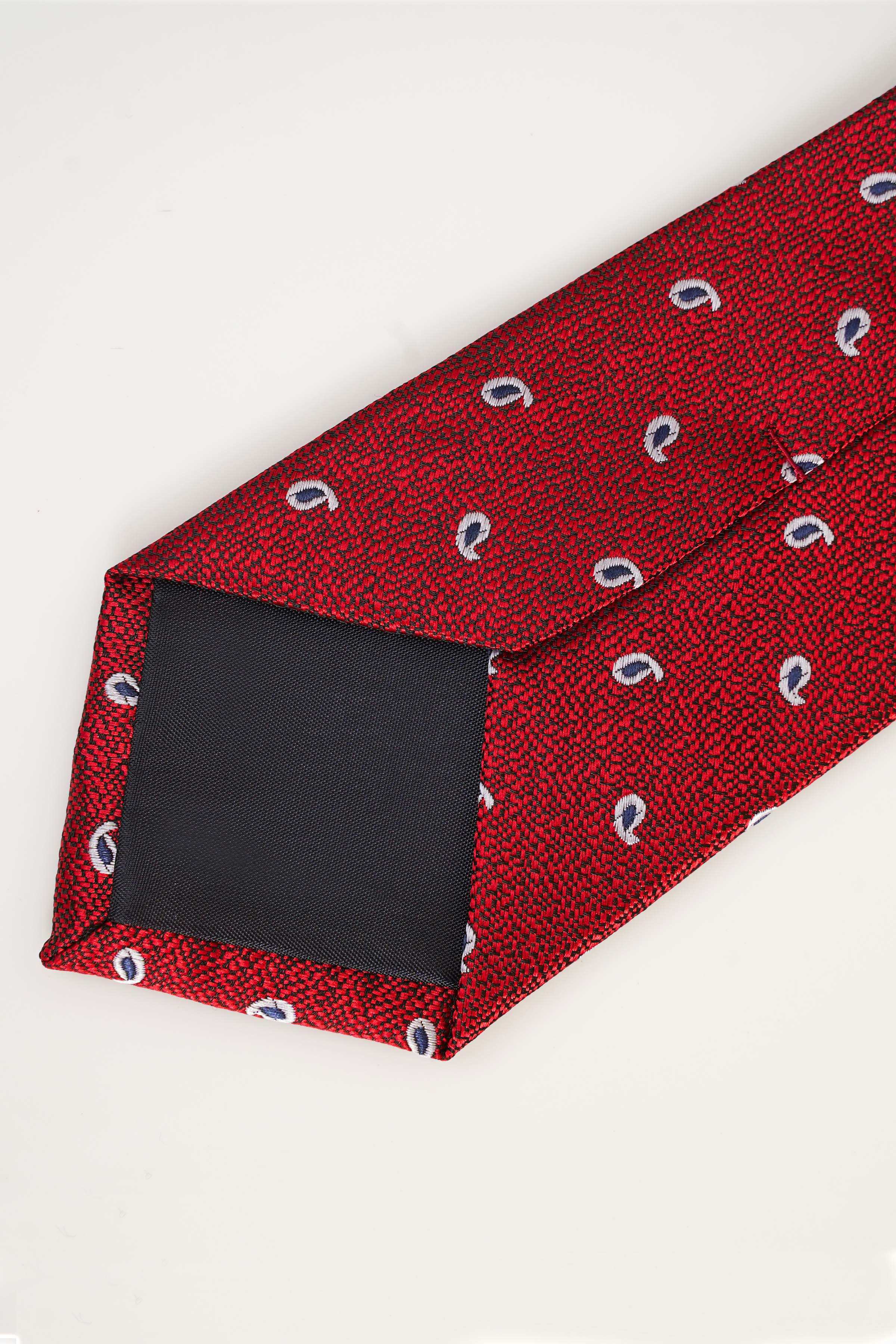 Red tie with blue dotted motifs, folded close-up showing texture and seam