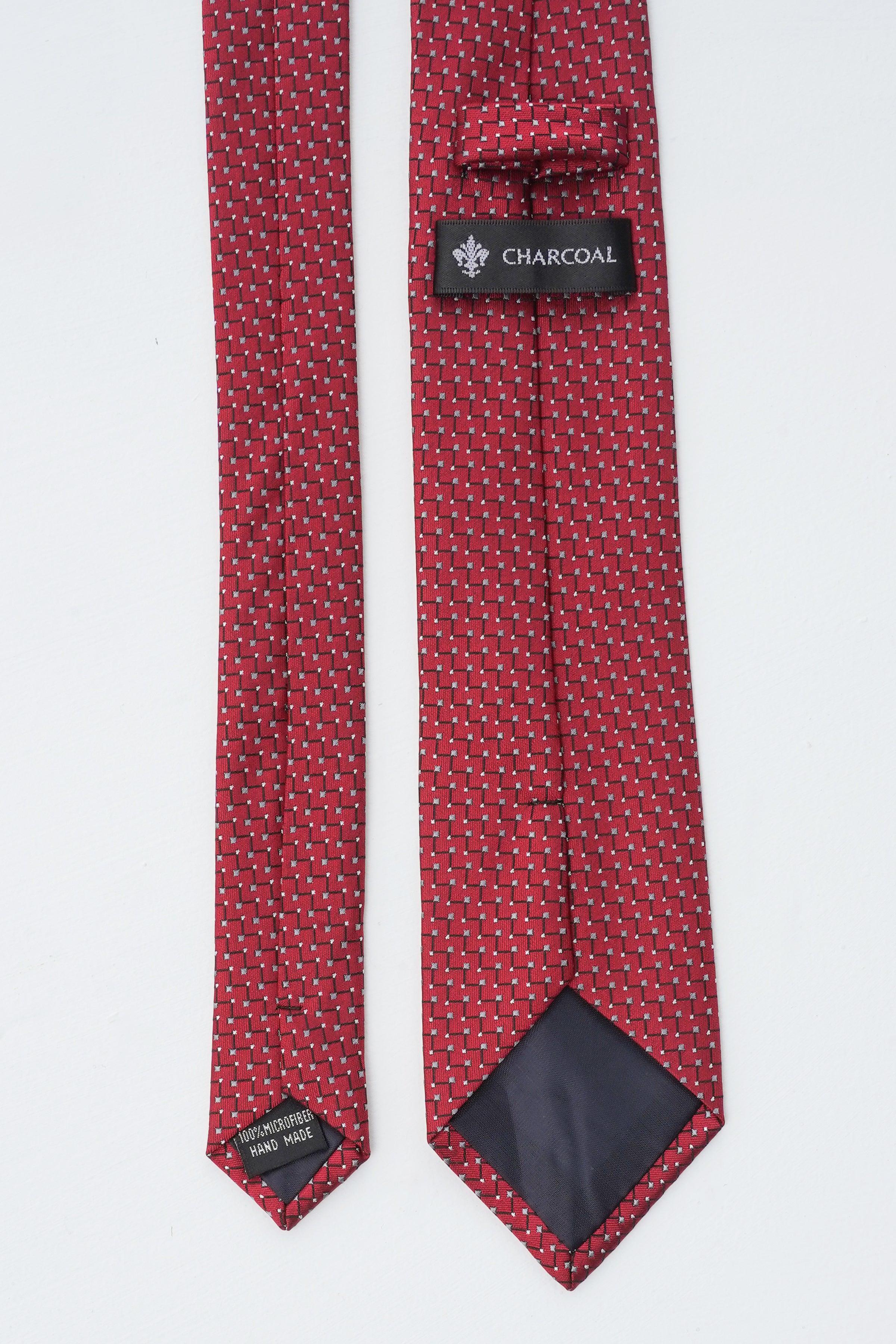 Poly silk tie with red geometric pattern and Charcoal label, darker lining visible