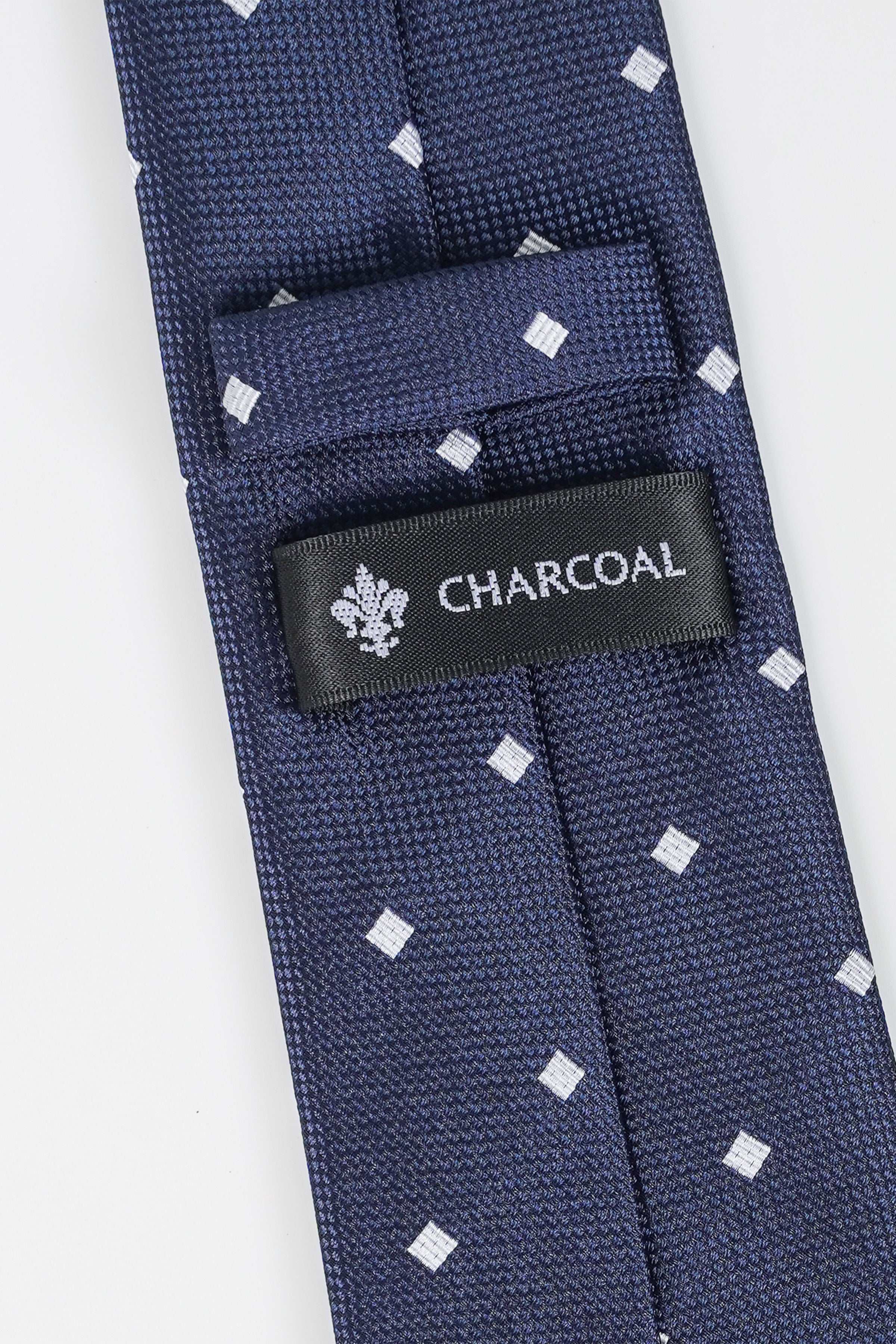Navy polyster tie with white square dots and CHARCOAL brand label on fold