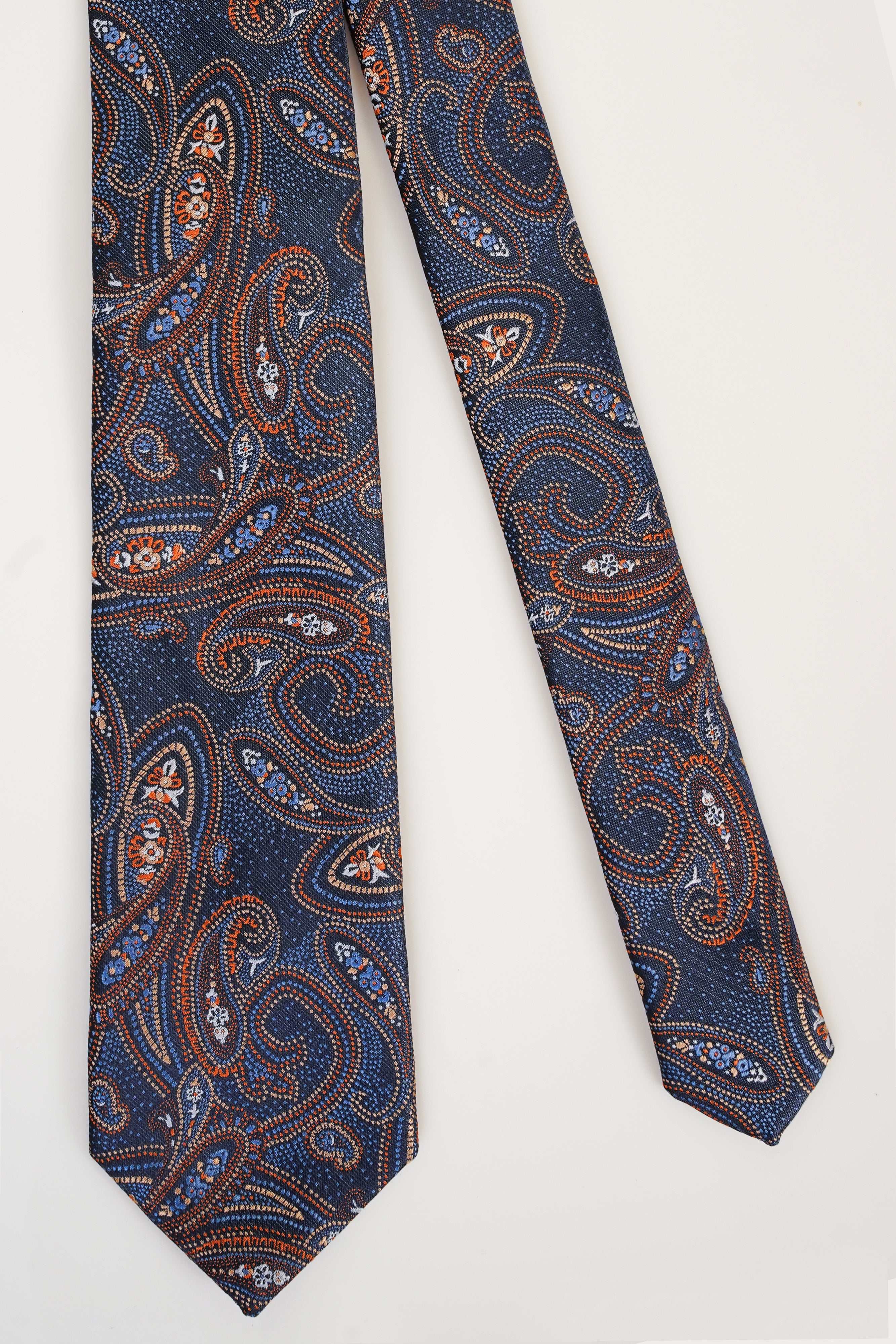 Poly silk tie in navy with paisley and swirl pattern, narrow end visible