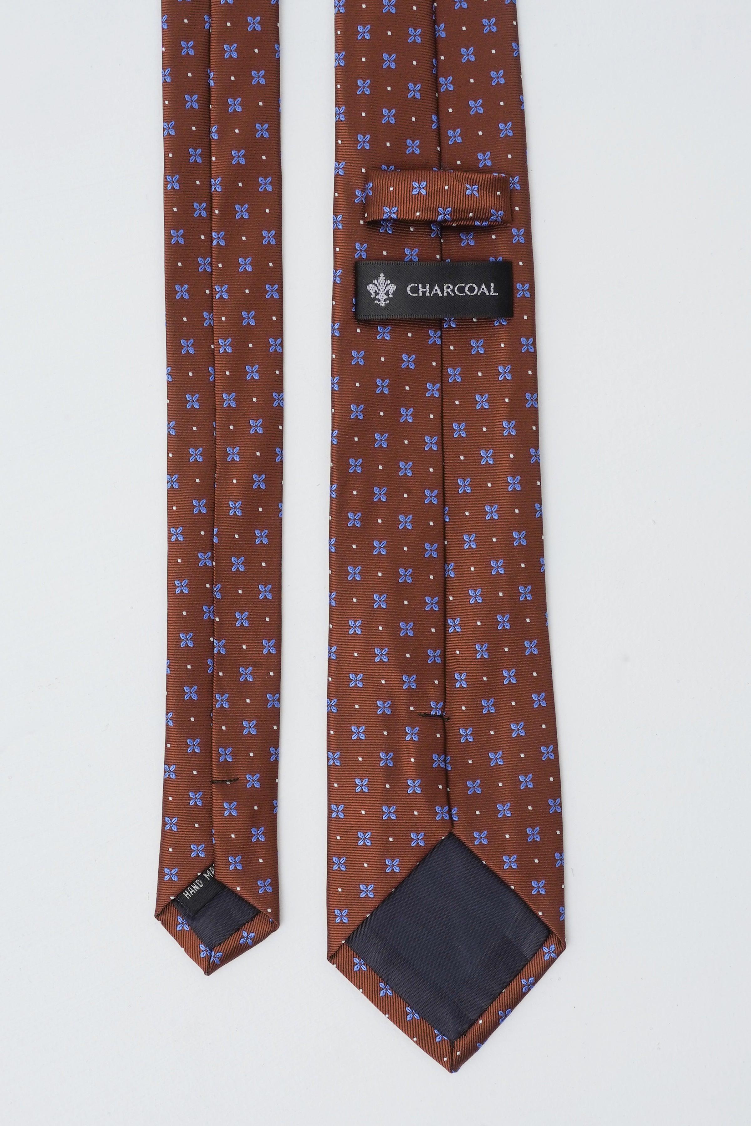 Brown patterned necktie with blue and light motifs and brand label at keeper.