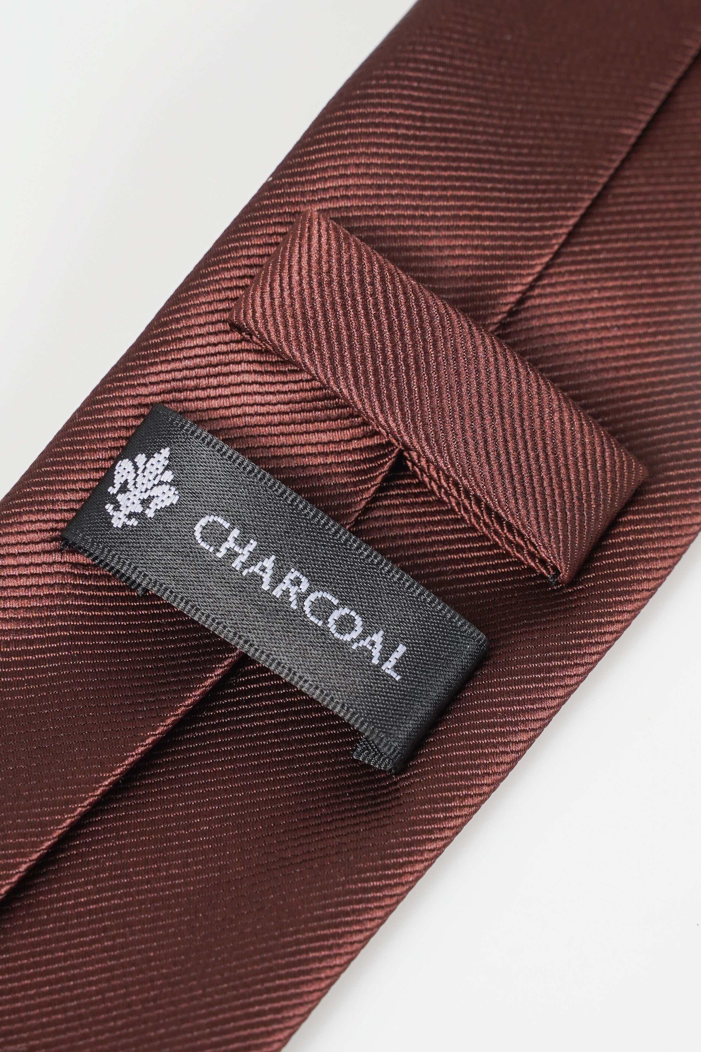 Poly silk necktie, burgundy textured weave, CHICOAKI brand label on keeper.
