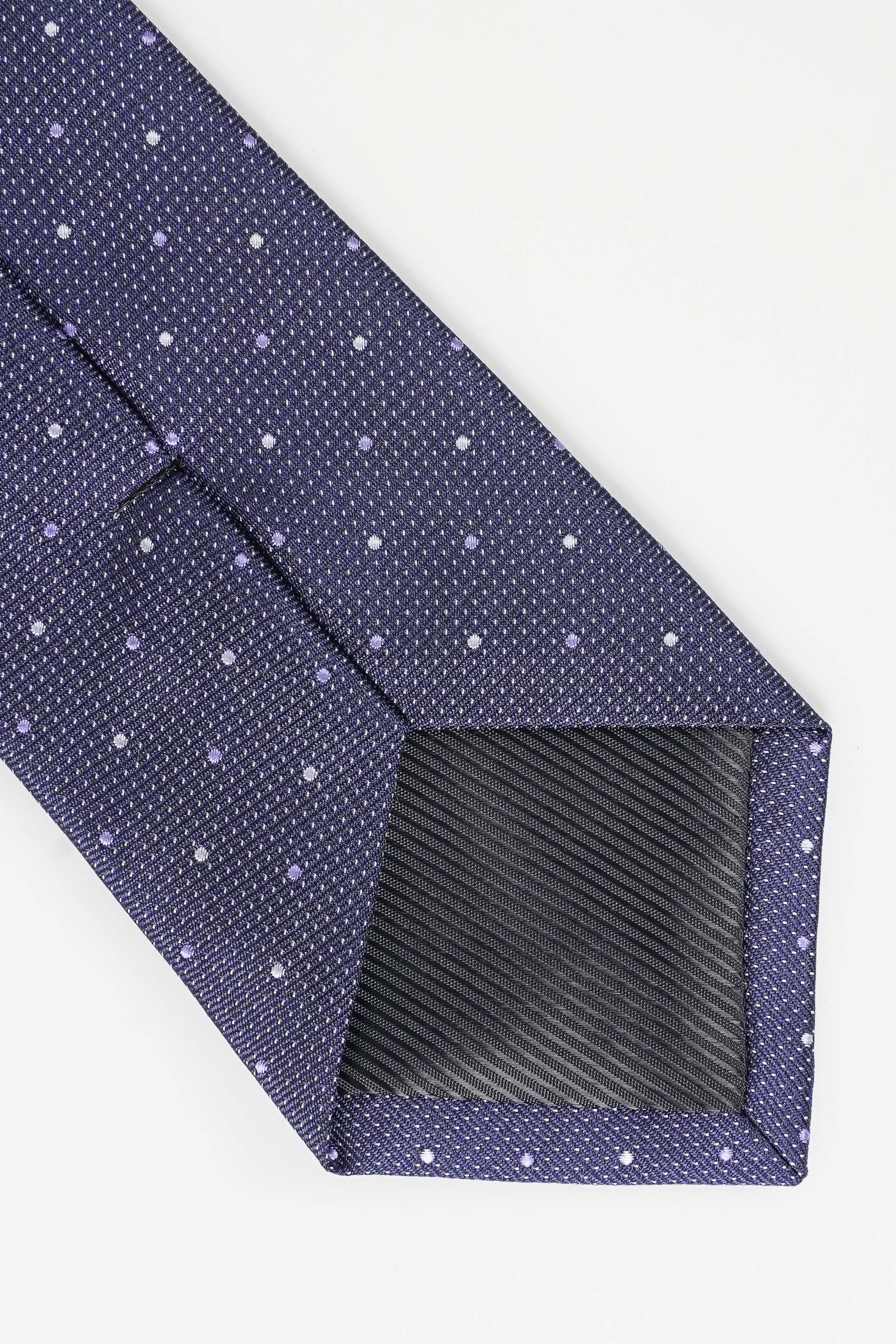 Dark blue tie corner with small white dot pattern and diagonal seam