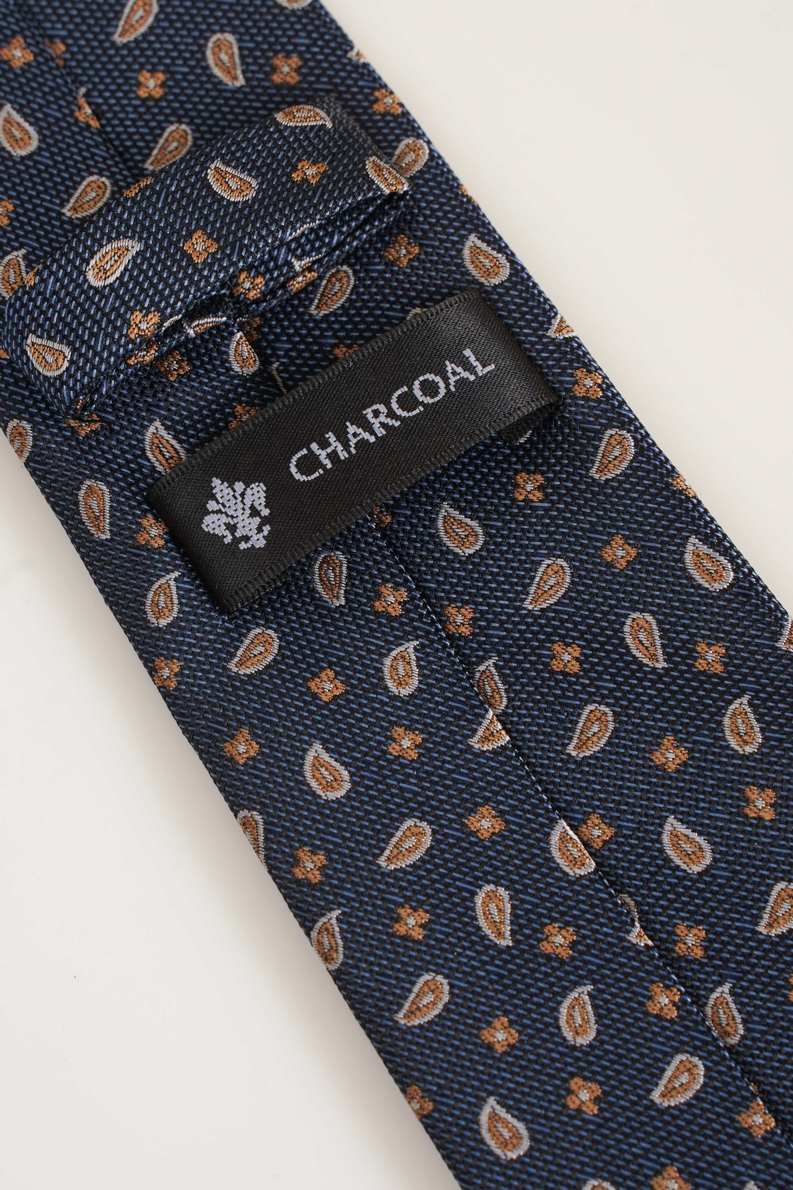 Poly silk tie with navy tan leaf pattern and CHARCOAL woven label