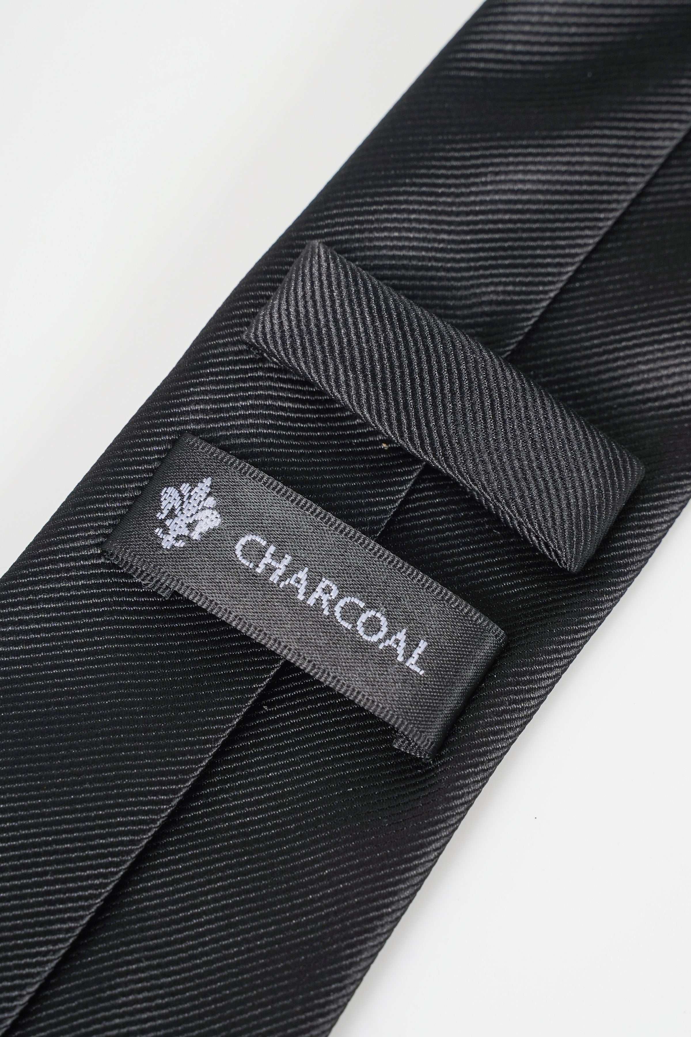 Dark poly silk tie with Charcoal label on keeper strap