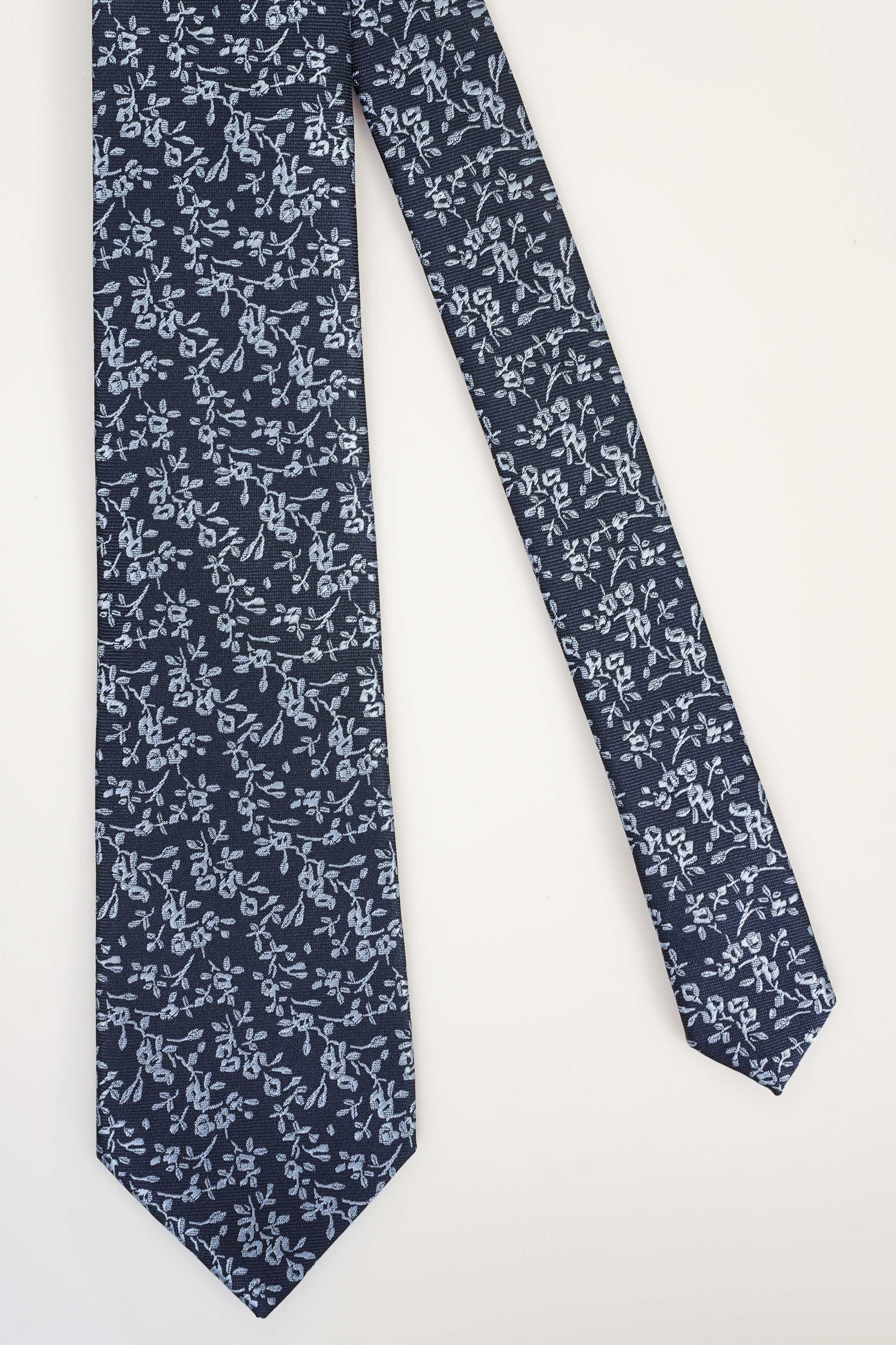 Poly silk tie in dark navy with white floral pattern and pointed end