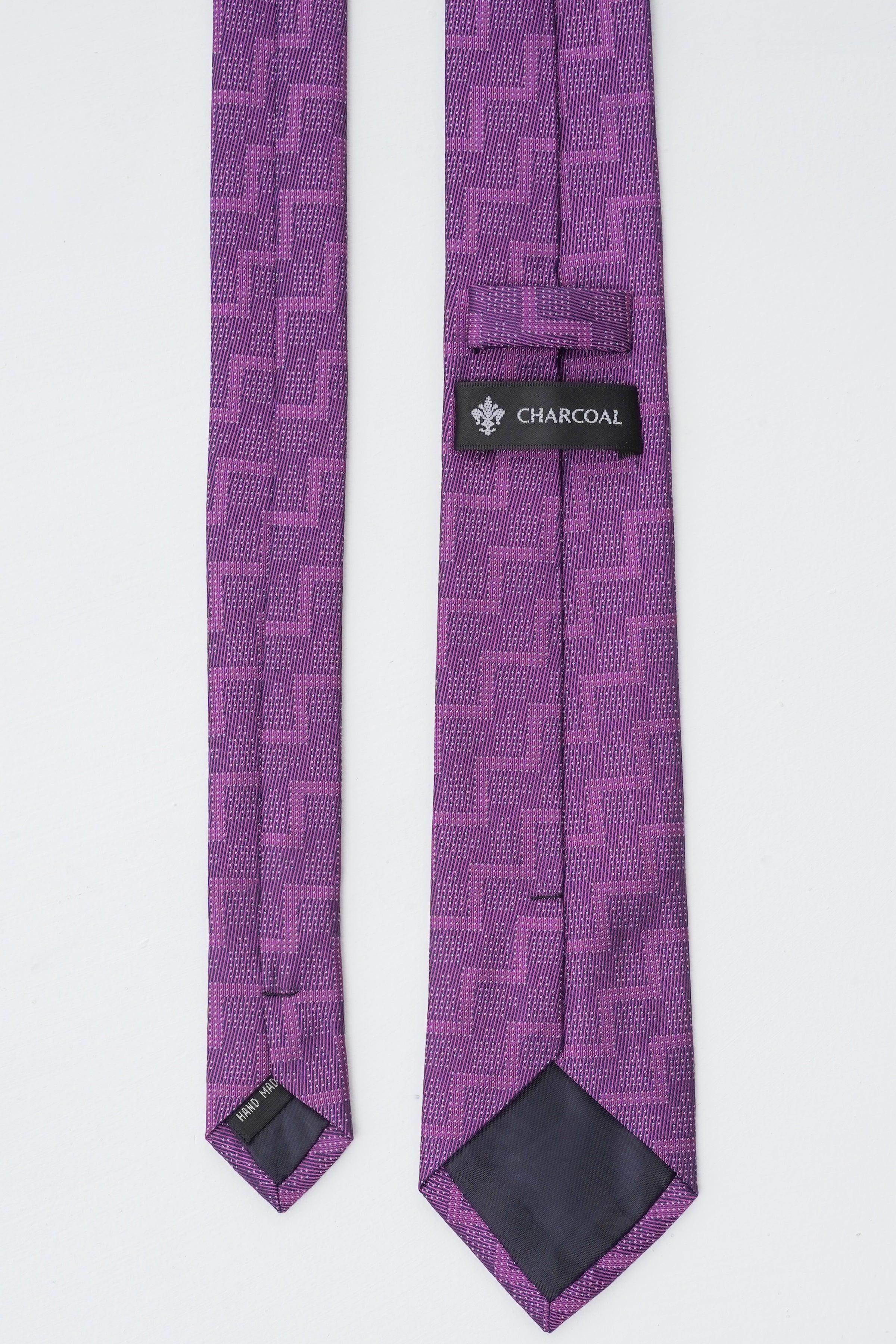Purple patterned necktie with label reading CHARCOAL near keeper, pointed end