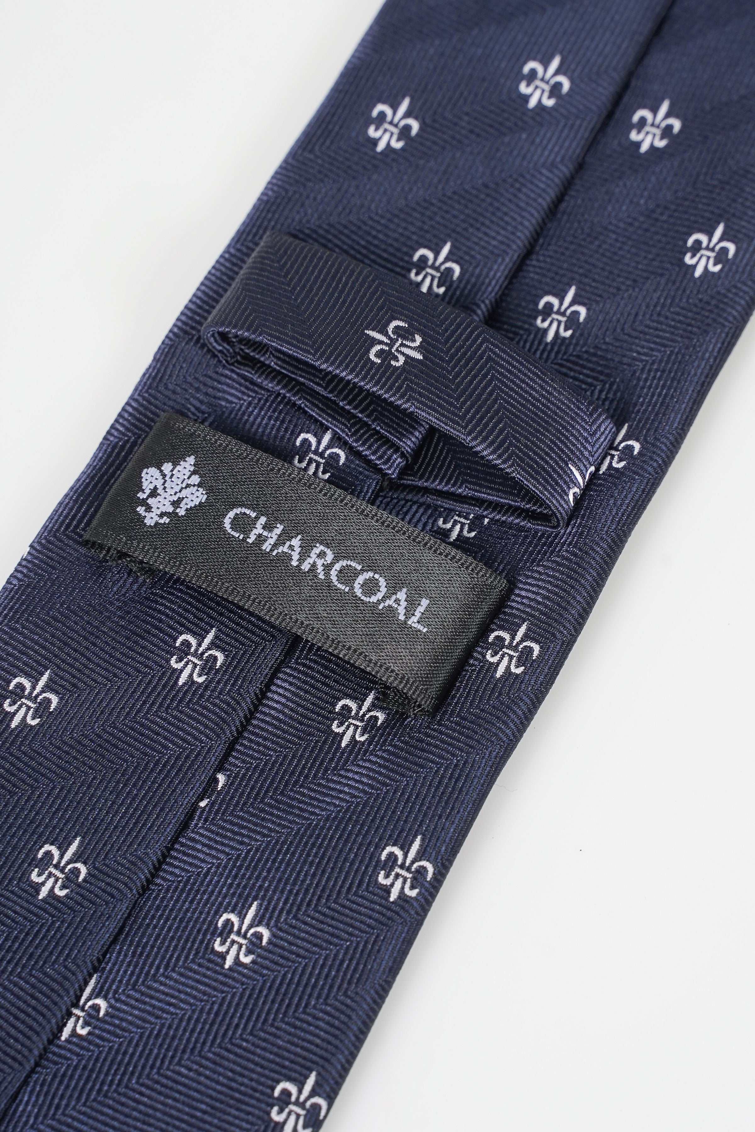 Dark navy tie with fleur-de-lis pattern and 'CHARCOAL' label near keeper