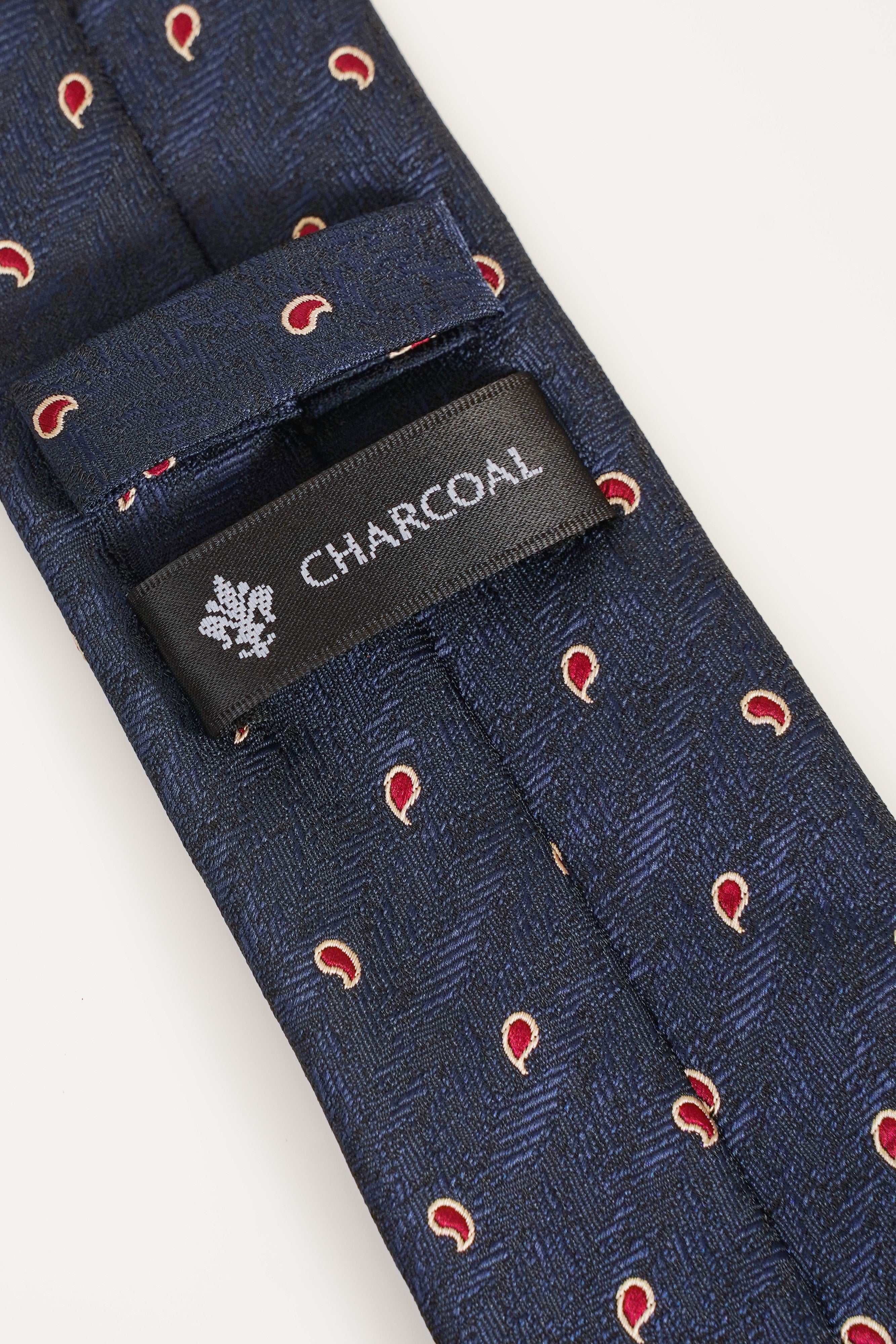Navy poly silk necktie with red pattern and charcoal brand label