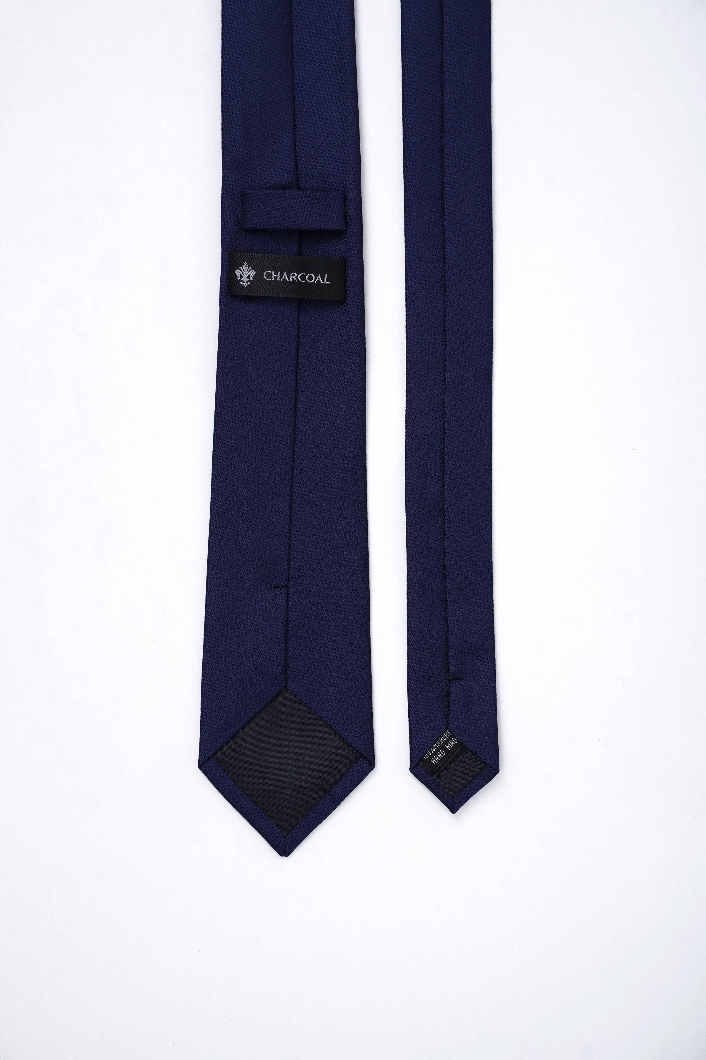 Dark navy poly silk neckties, folded with fabric keeper and small label patch