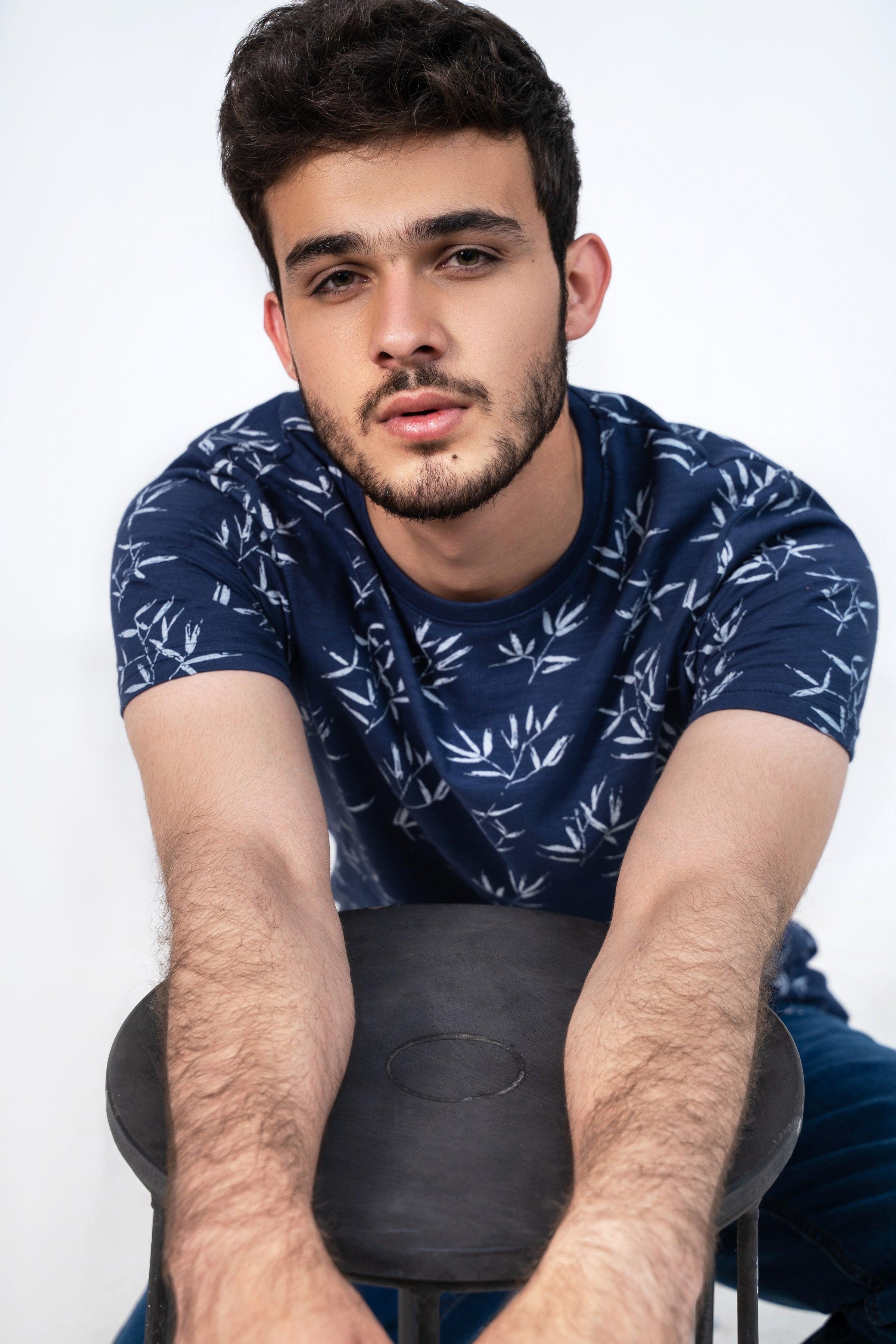 Men's navy printed T-shirt with white leaf pattern, close-up crew neck