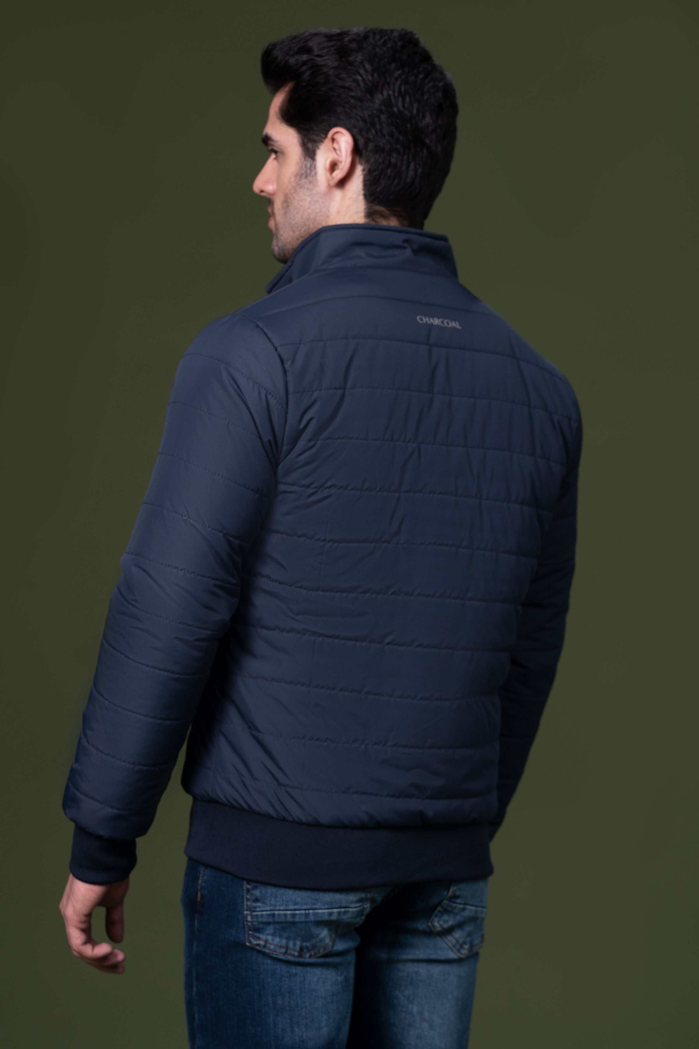 Navy puffer jacket back view with quilted panels and ribbed cuffs