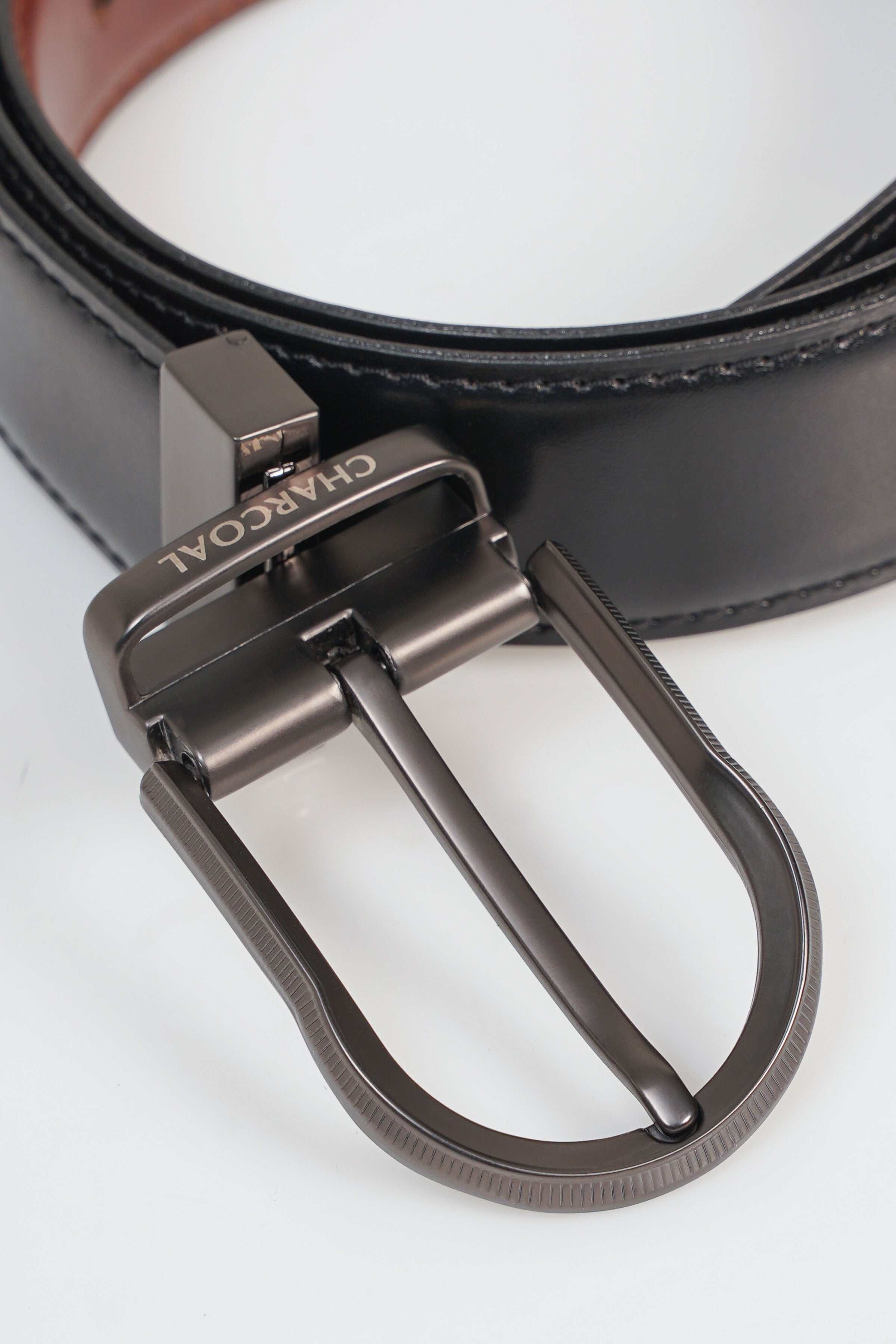 Reversible belt close-up: silver-tone buckle and dark strap with stitched edges