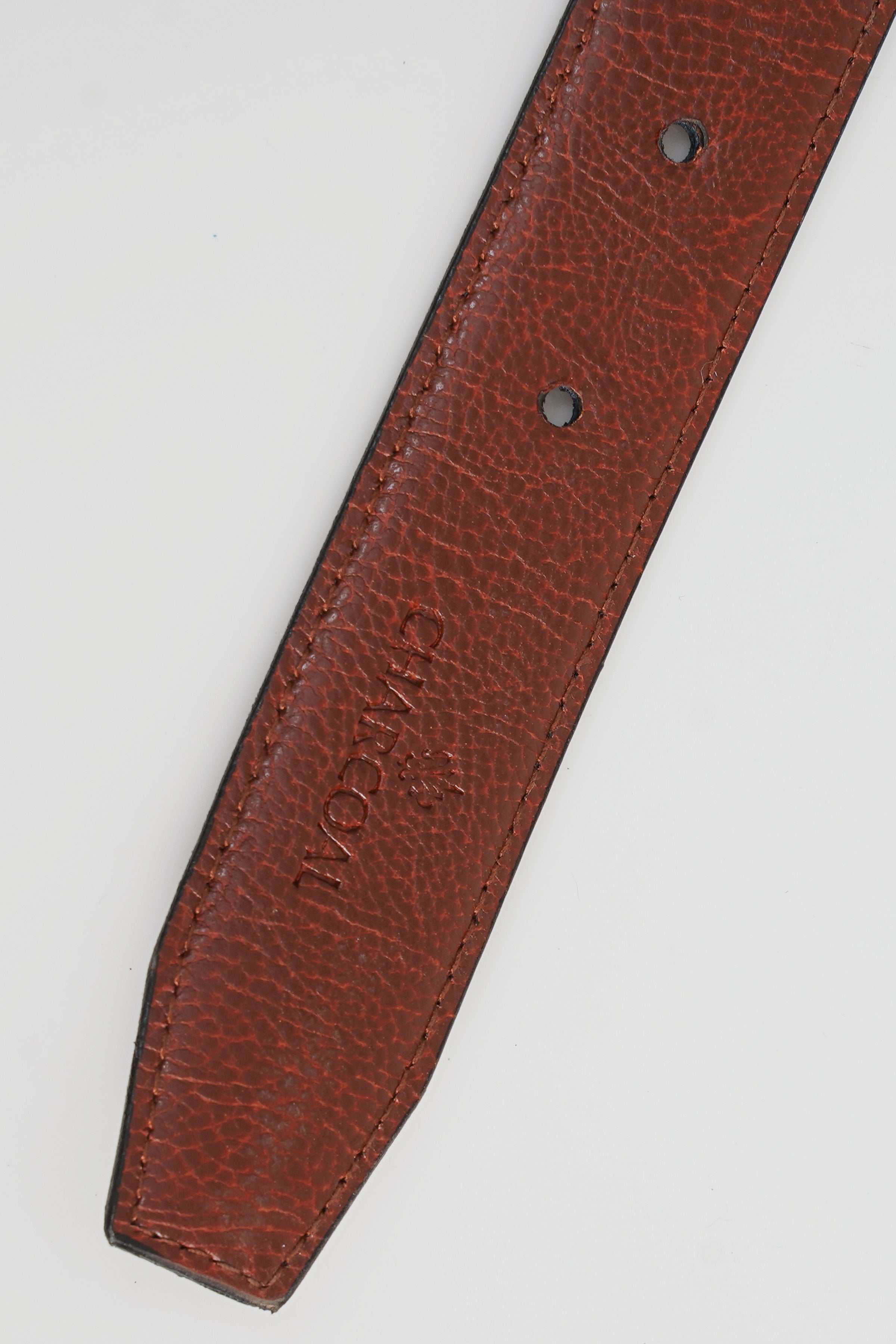Reversible belt strap with punched holes and embossed logo on brown leather