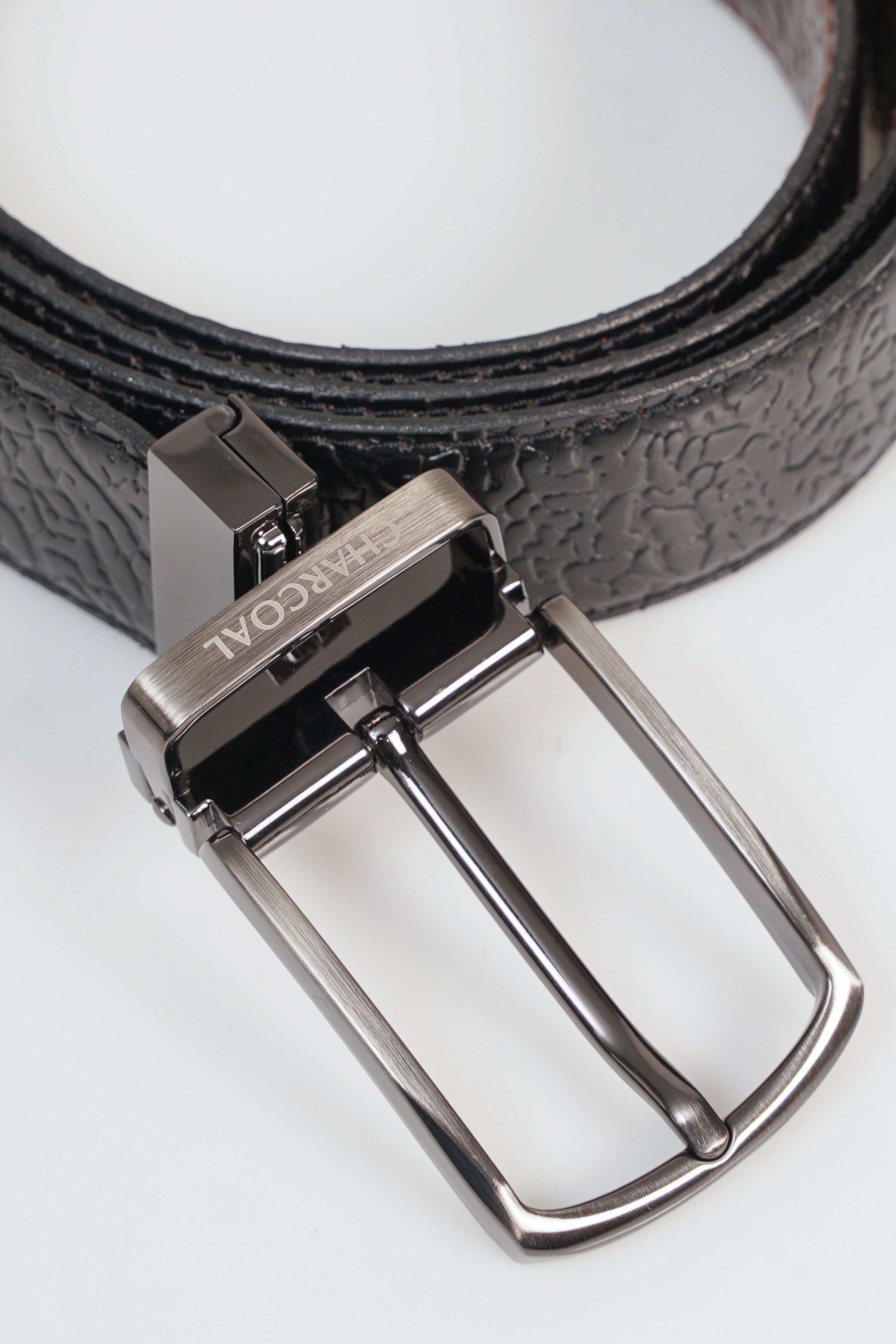 Leather belt buckle with textured strap and silver-tone metal clasp.
