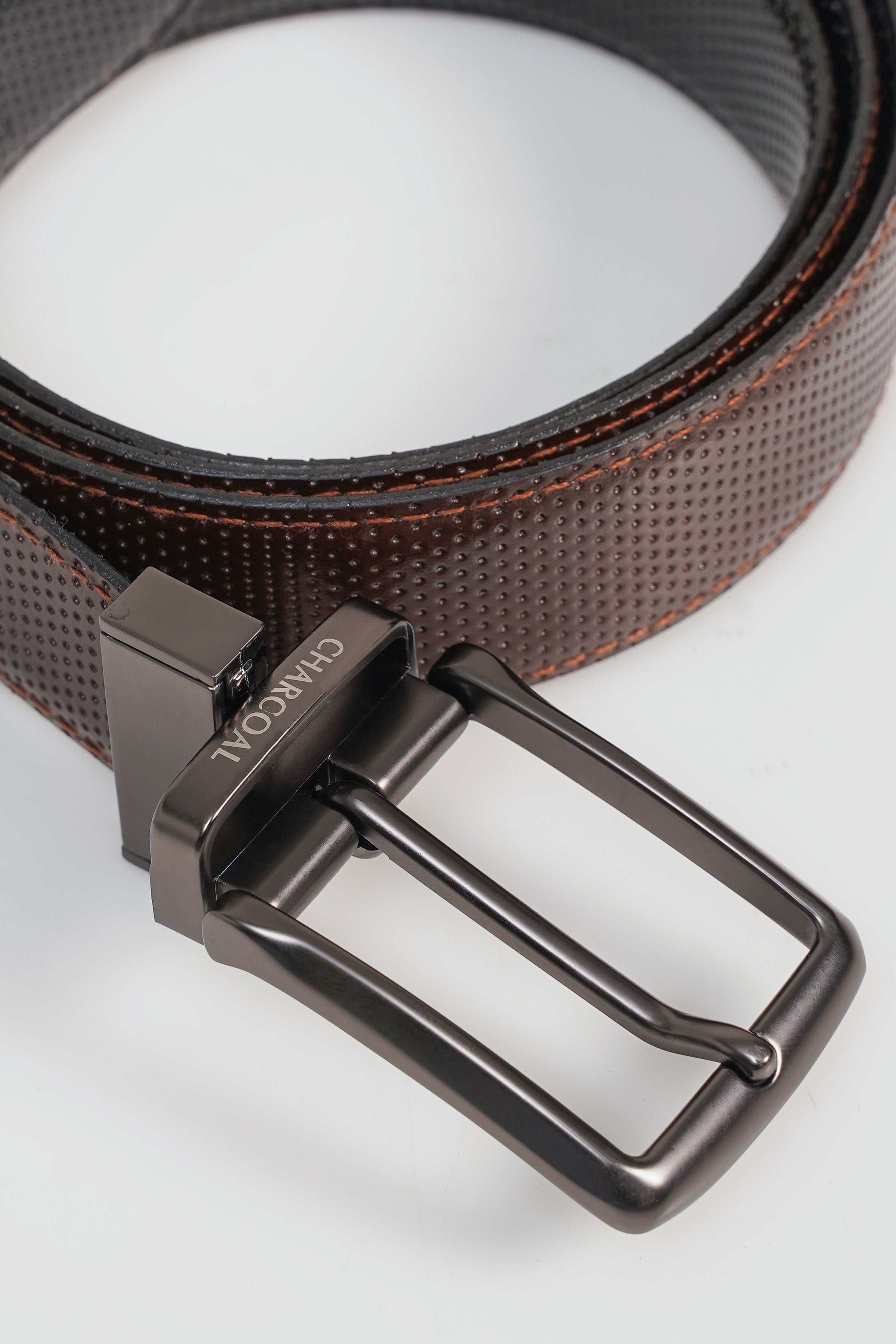 Reversible belt, close-up of gunmetal buckle with engraved brand lettering