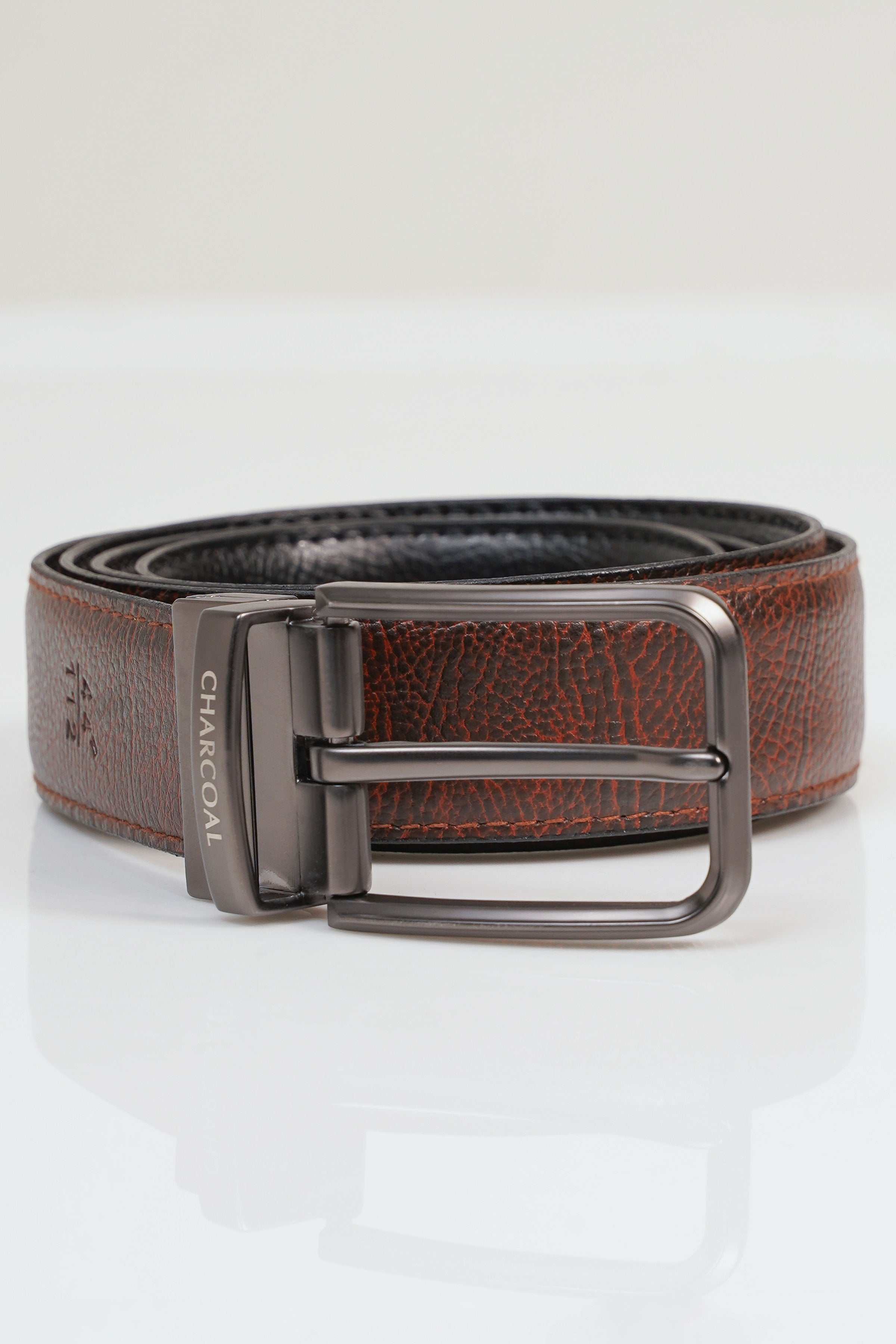 Reversible belt with brown leather, black inner side, and metal buckle