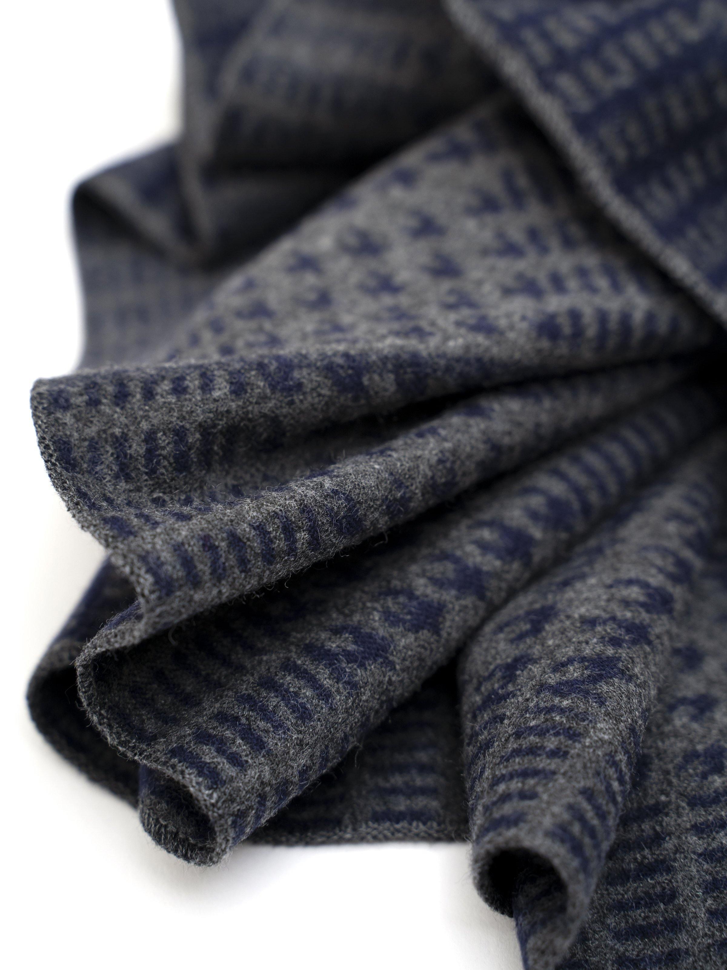 Folded dark navy scarf showing fine geometric weave pattern