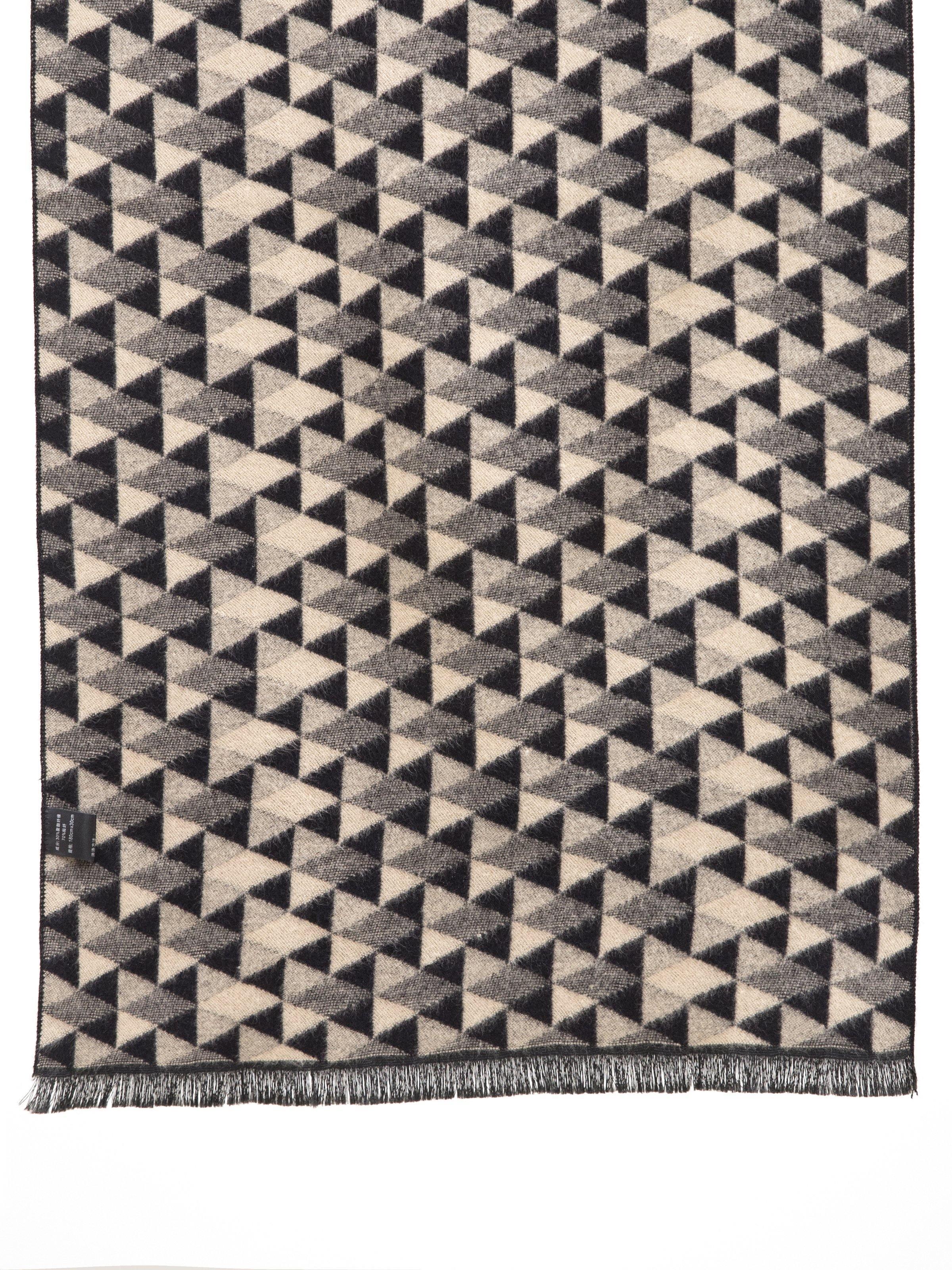 Geometric triangle scarf in black, gray, and cream with fringed hem.