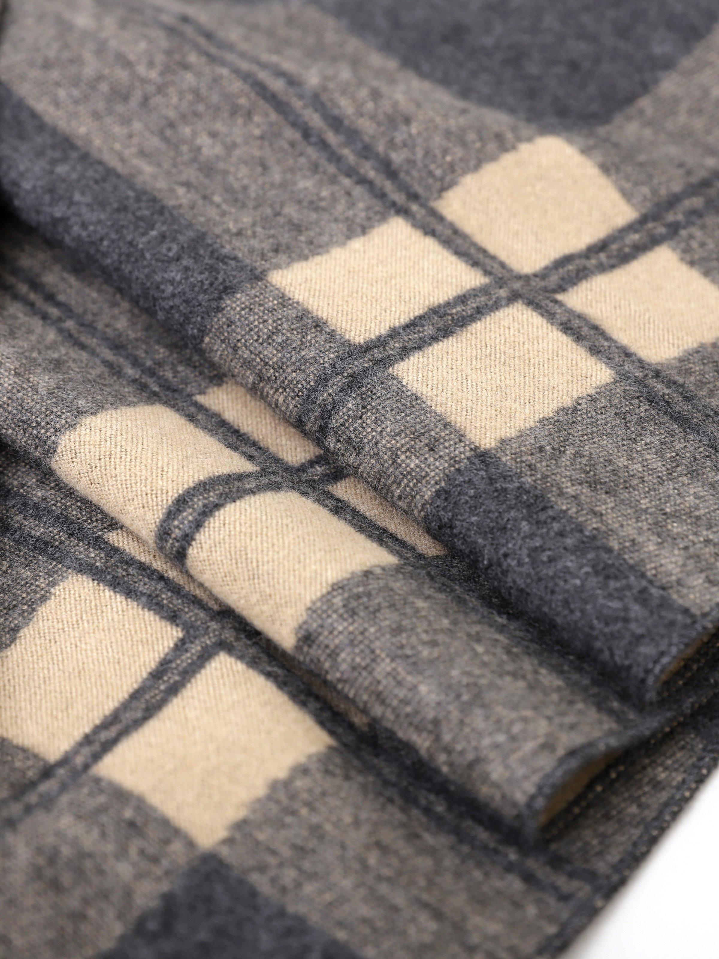 Plaid scarf fabric close-up with dark gray and beige blocks