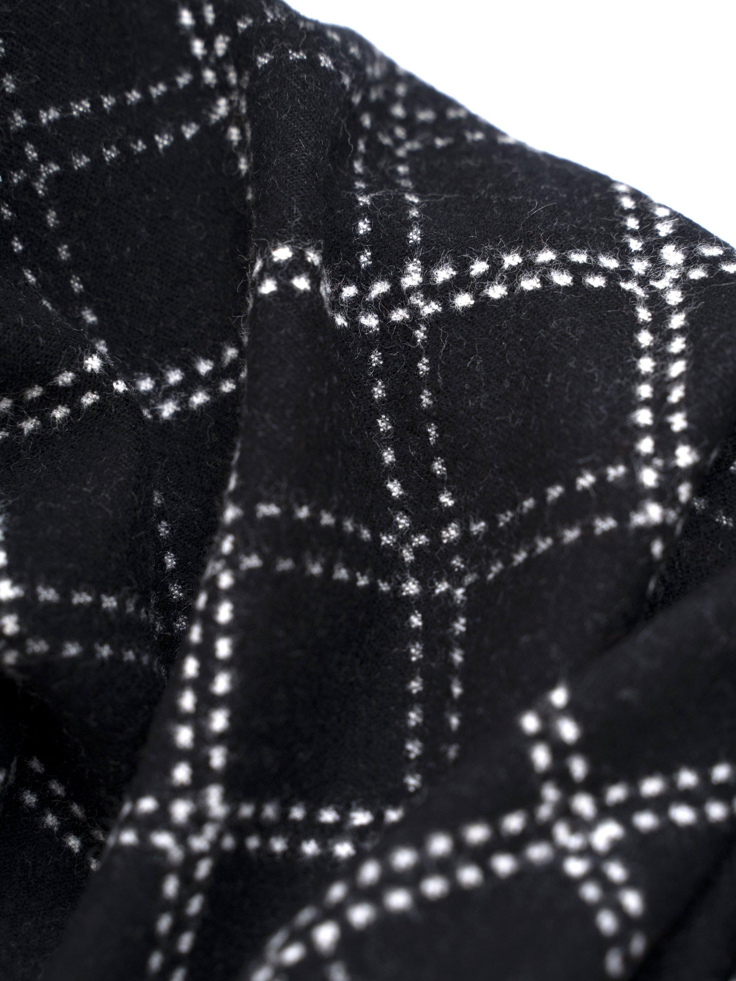 Scarf close-up: black fabric with white grid check pattern.
