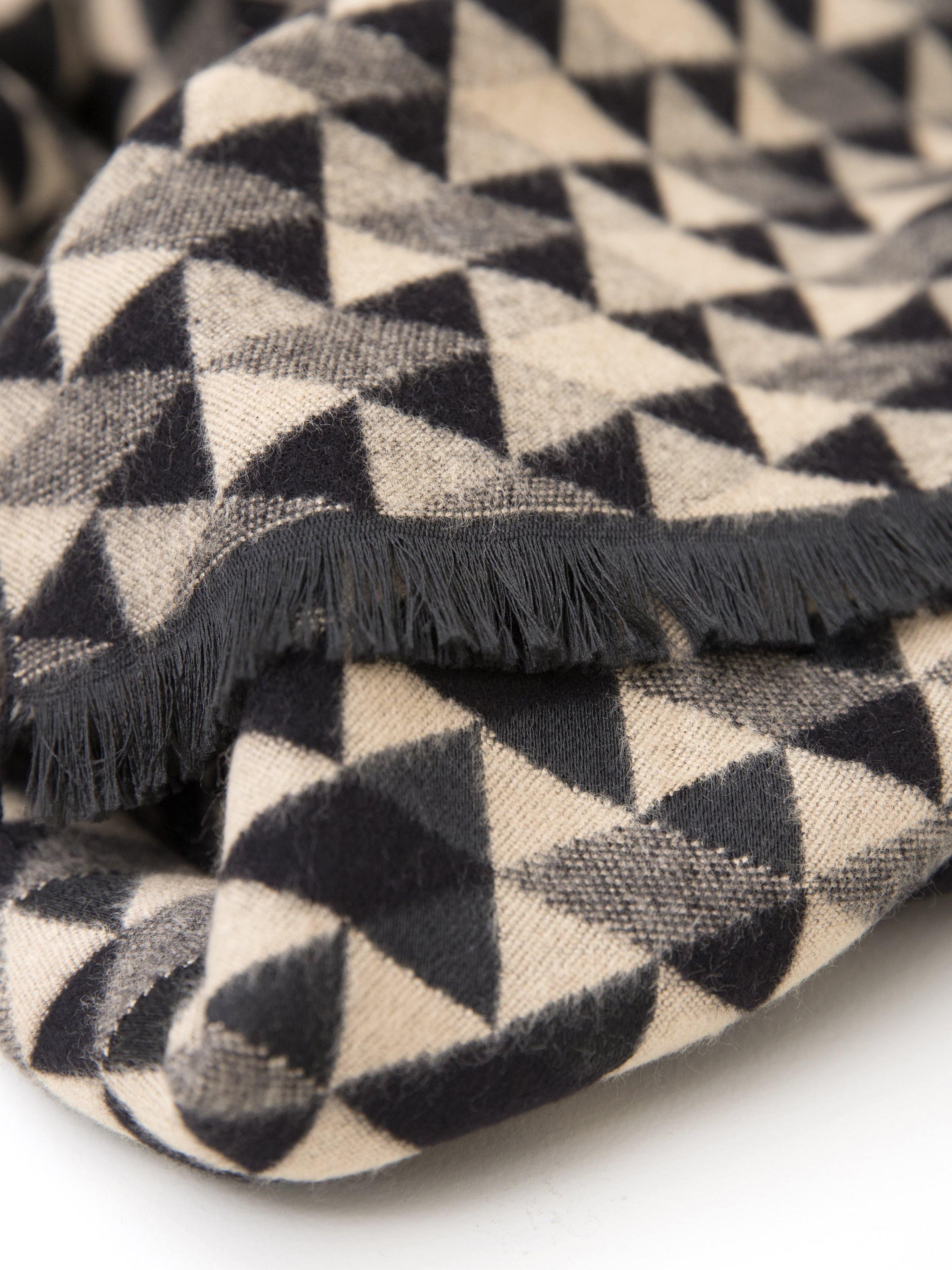 Geometric triangle scarf with fringed edge in black, gray, and cream tones.