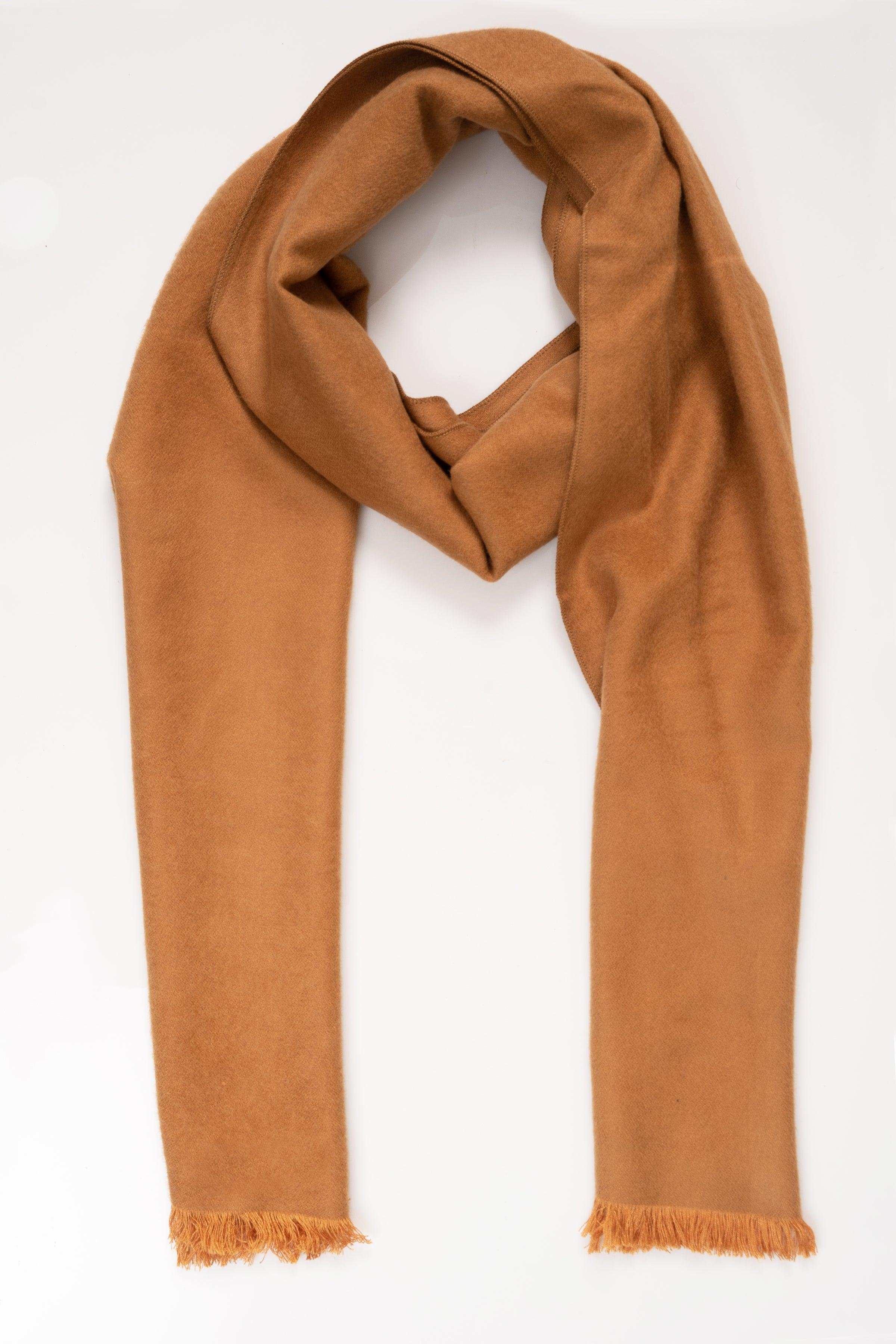Draped tan scarf with soft texture and fringed ends