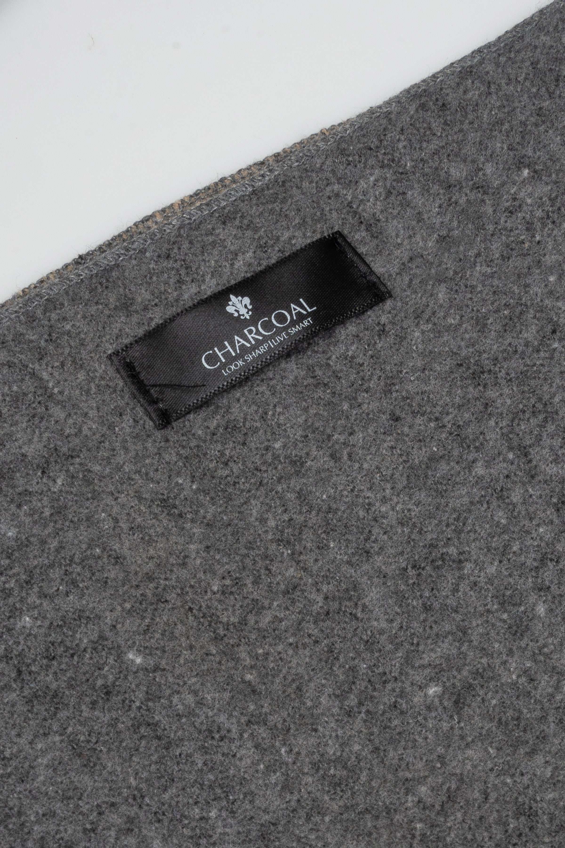 Charcoal scarf fabric label patch on dark gray knit