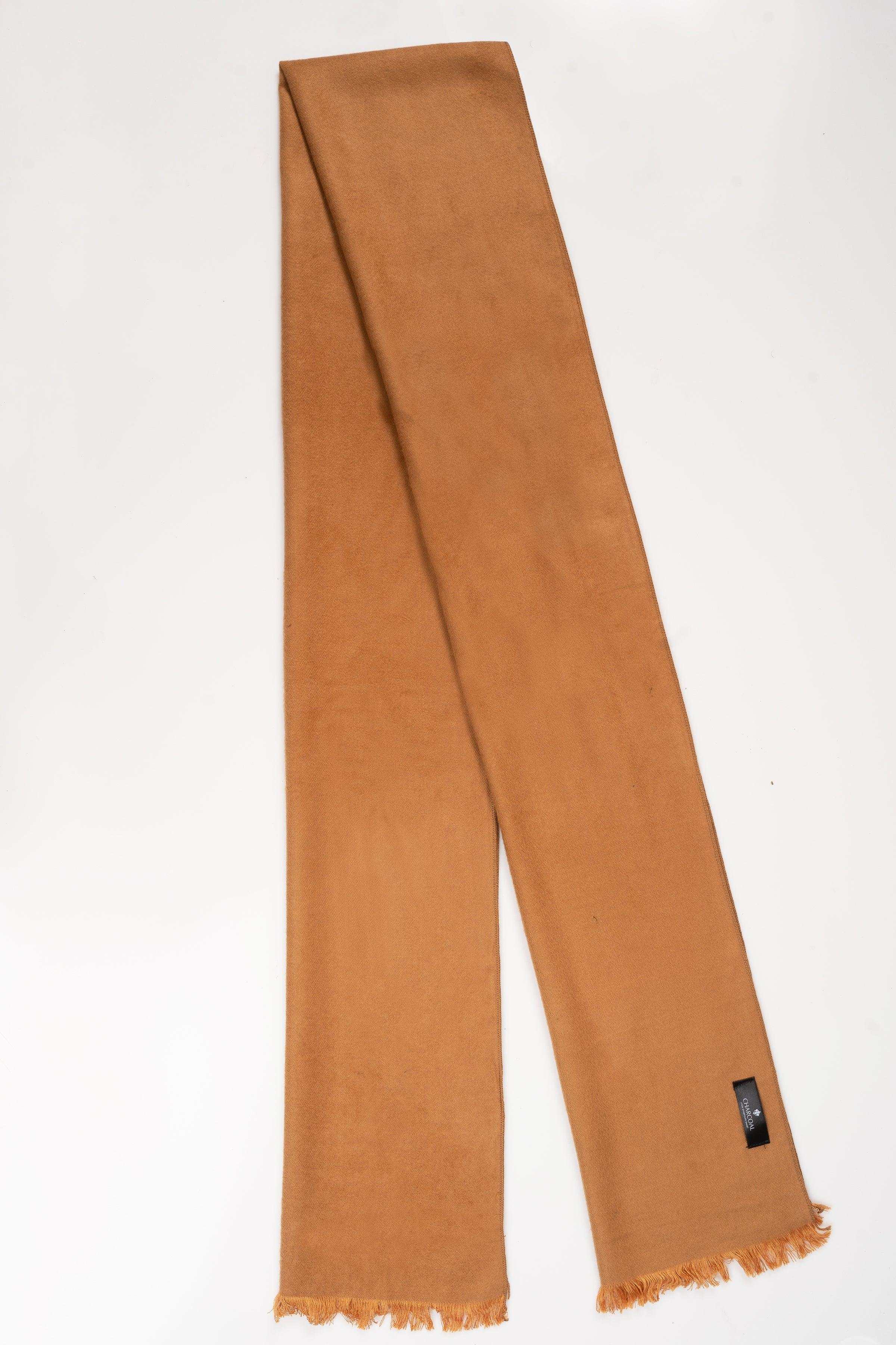 Tan long scarf with frayed ends and small fabric tag