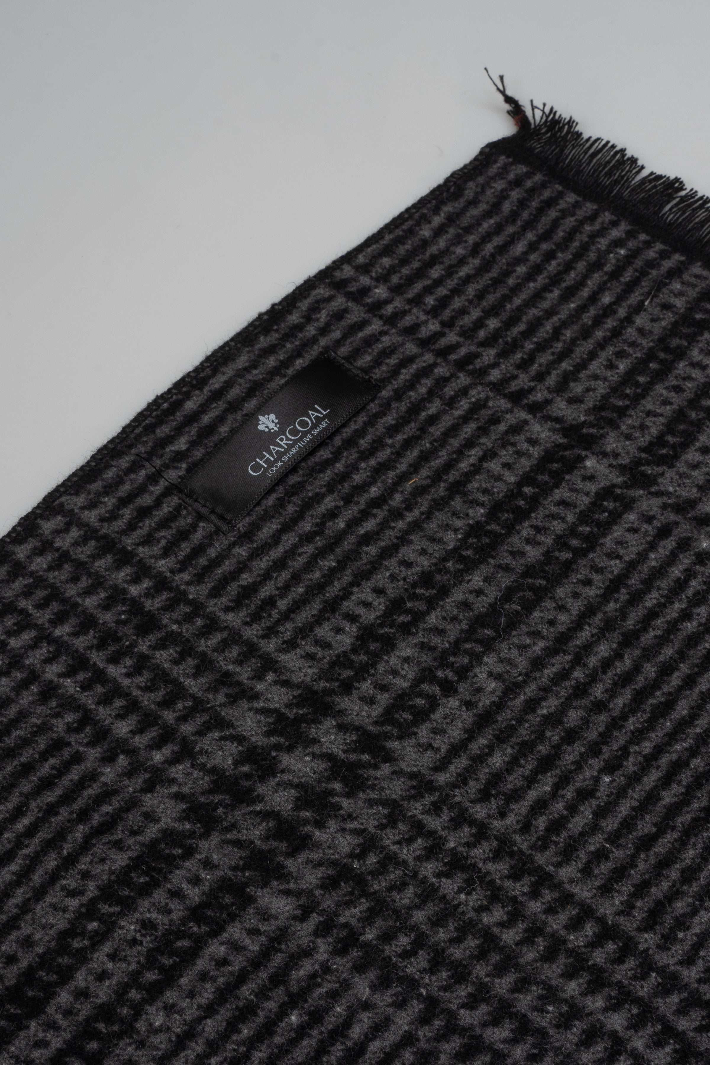 Charcoal plaid scarf corner with black fringe and logo patch