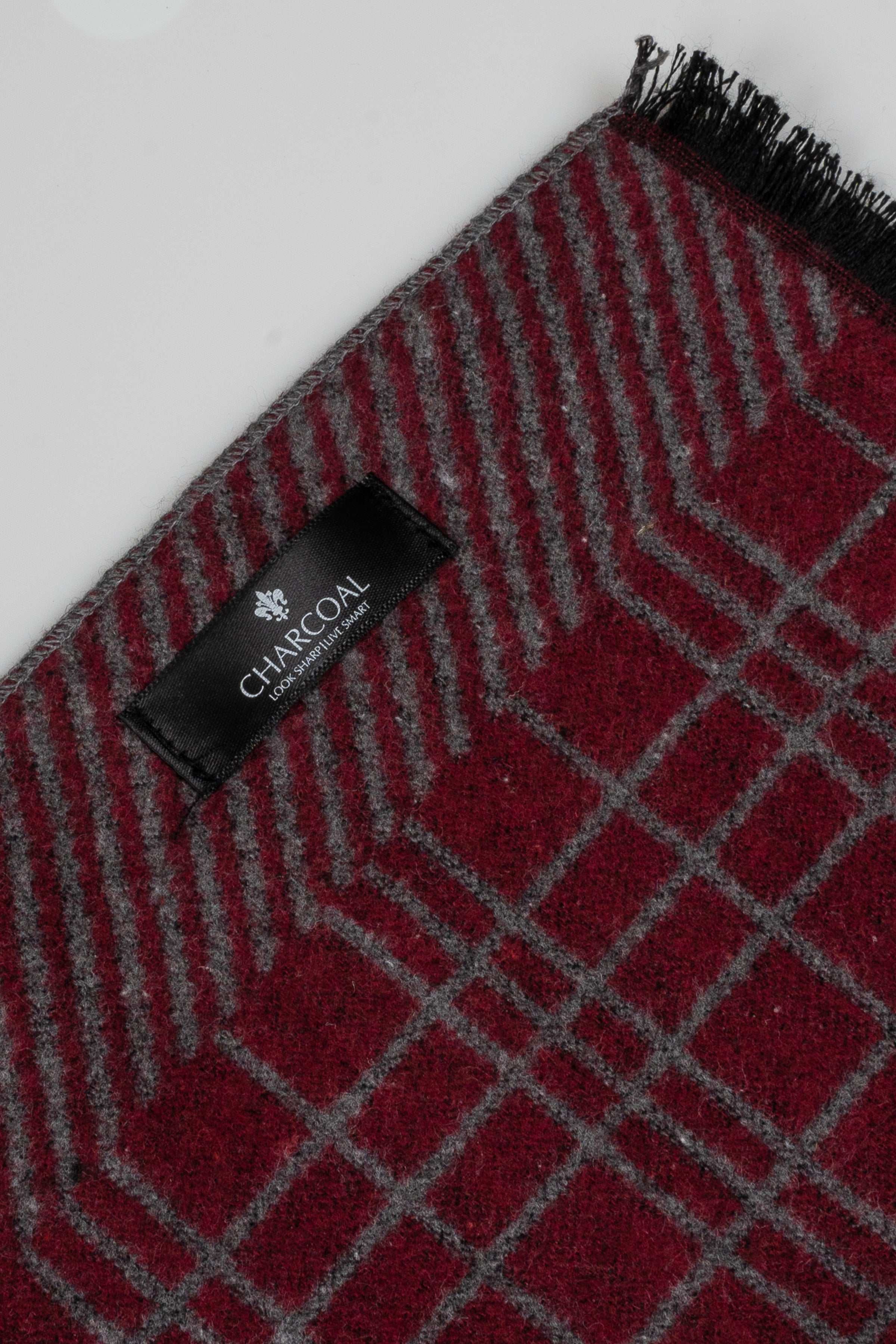 Plaid scarf close-up with red grid pattern, charcoal gray, fringed edge and label