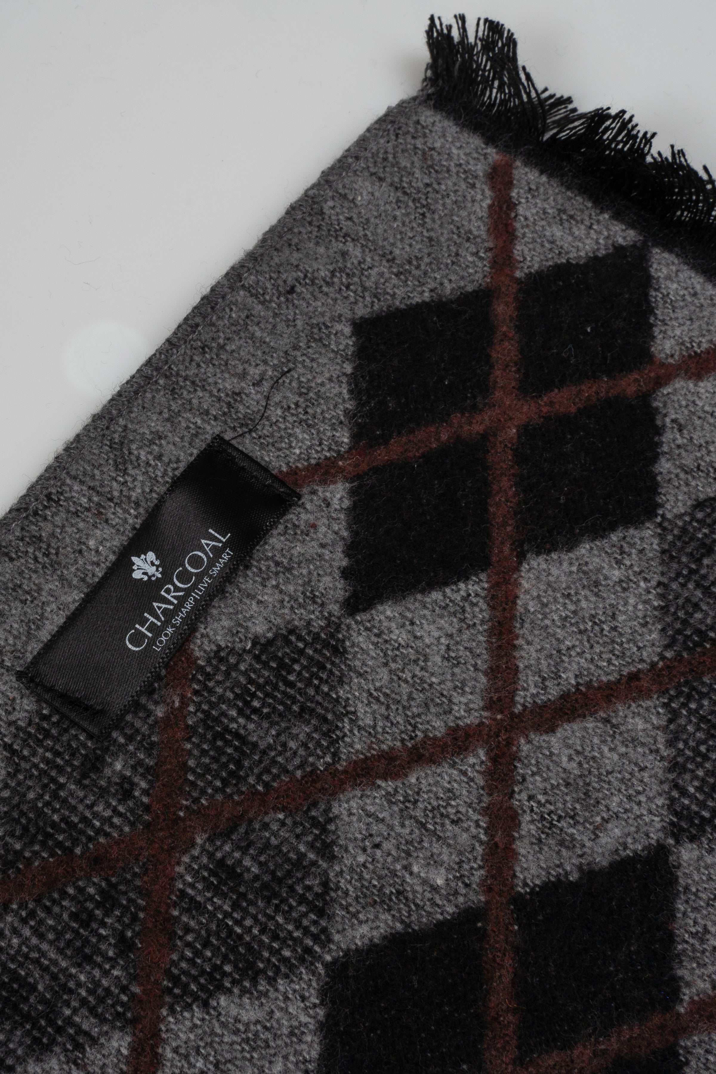 Grey scarf close-up with black-and-brown argyle pattern and woven label