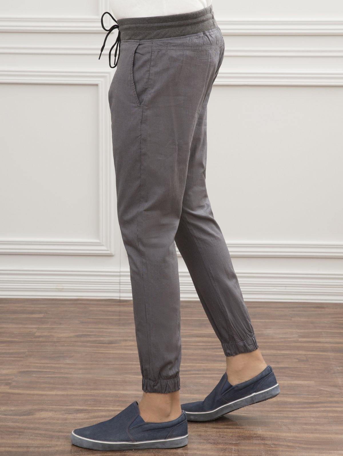 Grey slim-fit trousers with drawstring waist and elastic cuffs, side view