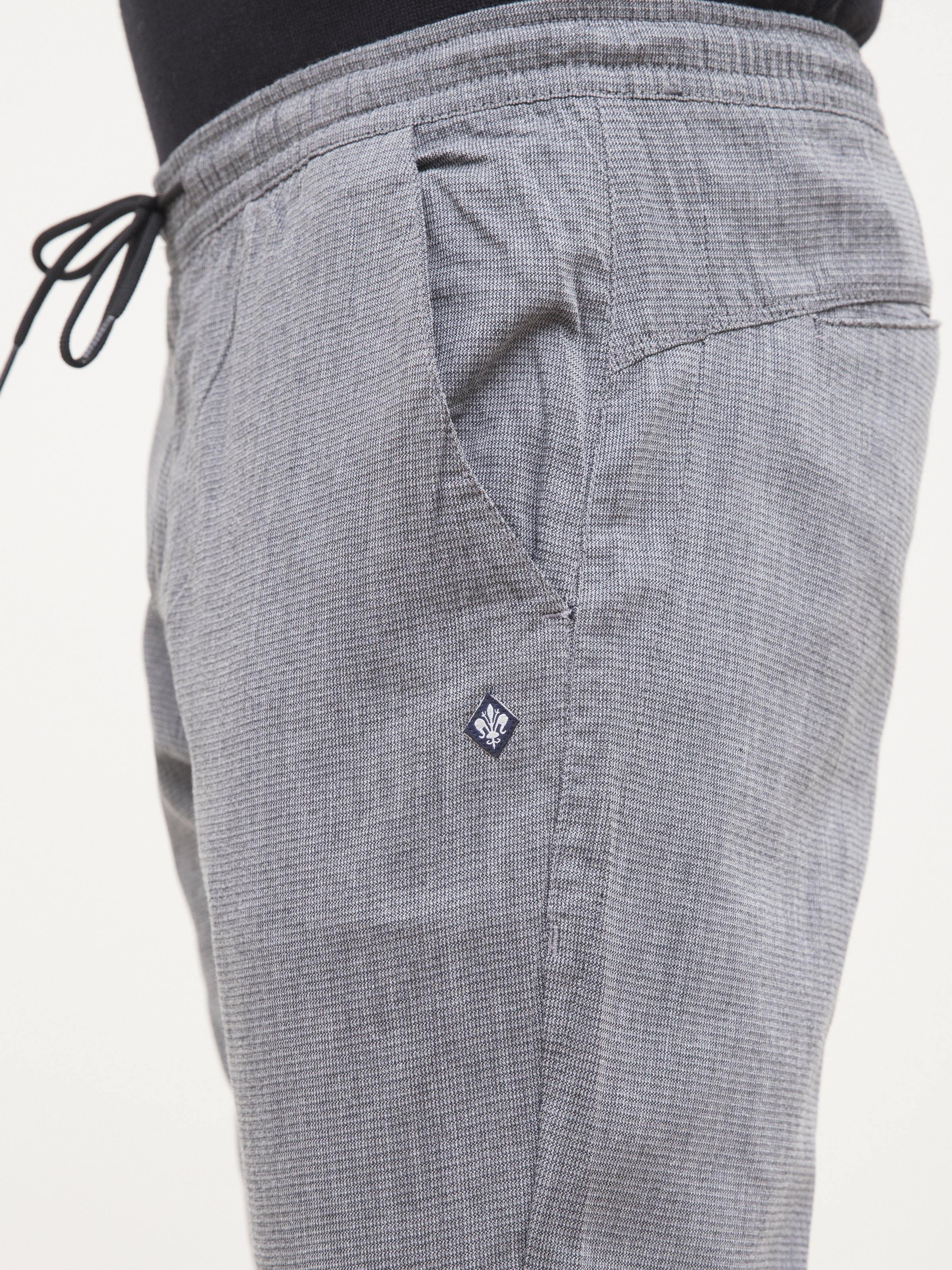 Light gray self-textured trousers detail: back yoke, pocket, and diamond logo