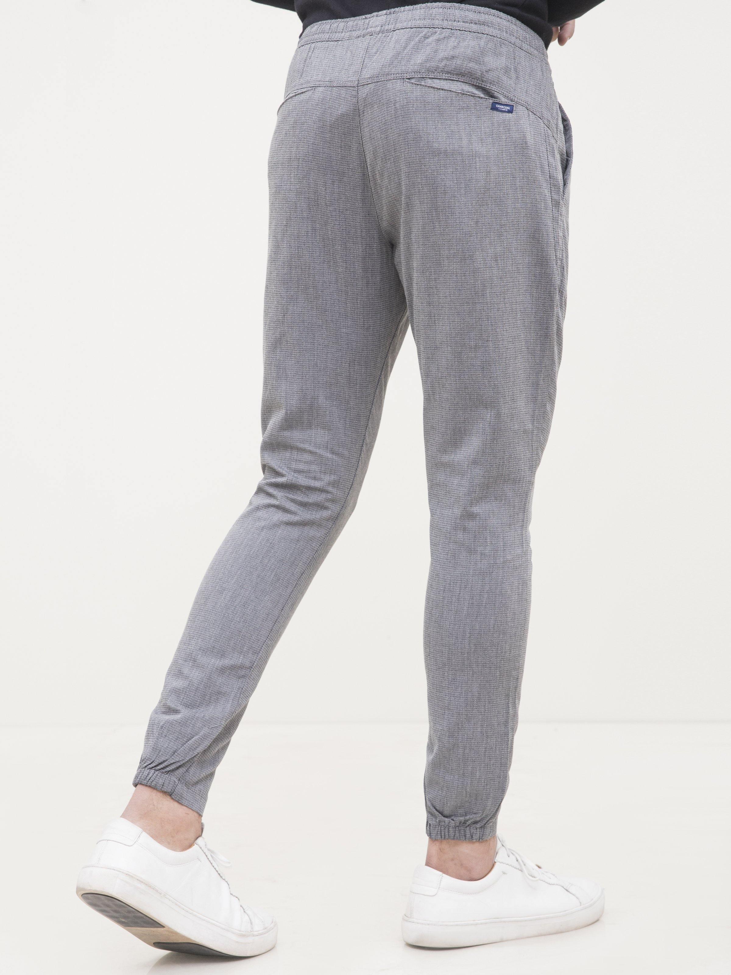 Back view of light gray casual trousers with drawstring waist and tapered fit
