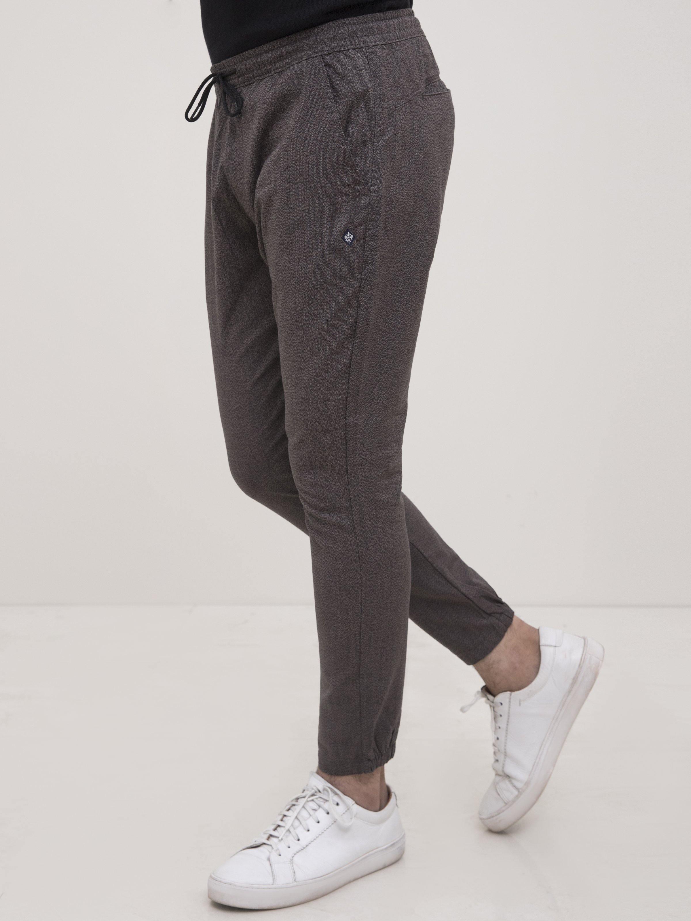 Dark gray tapered trousers with drawstring waist and cuffed hems, side pockets