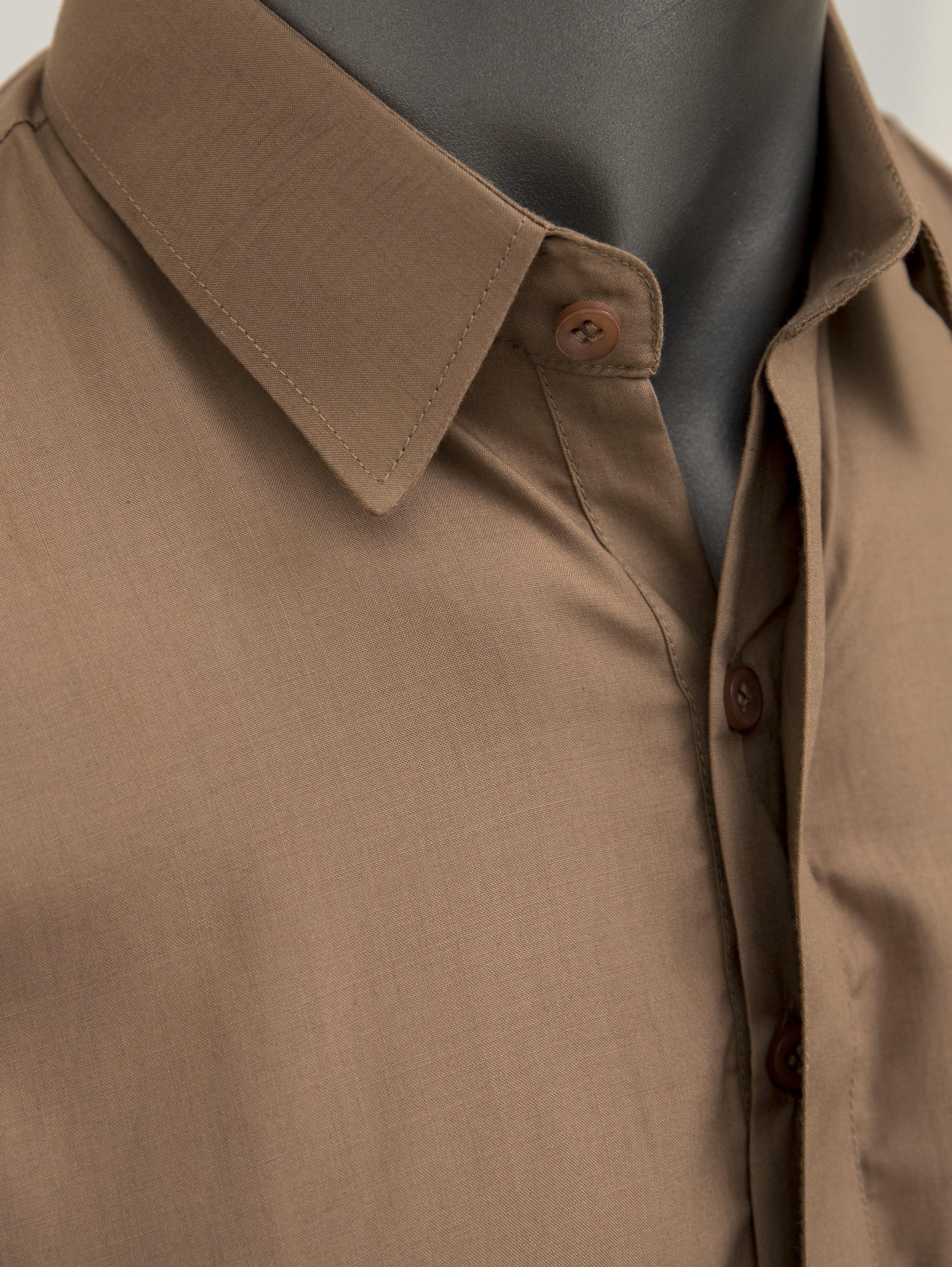Brown kameez collar and button placket with visible textured fabric weave